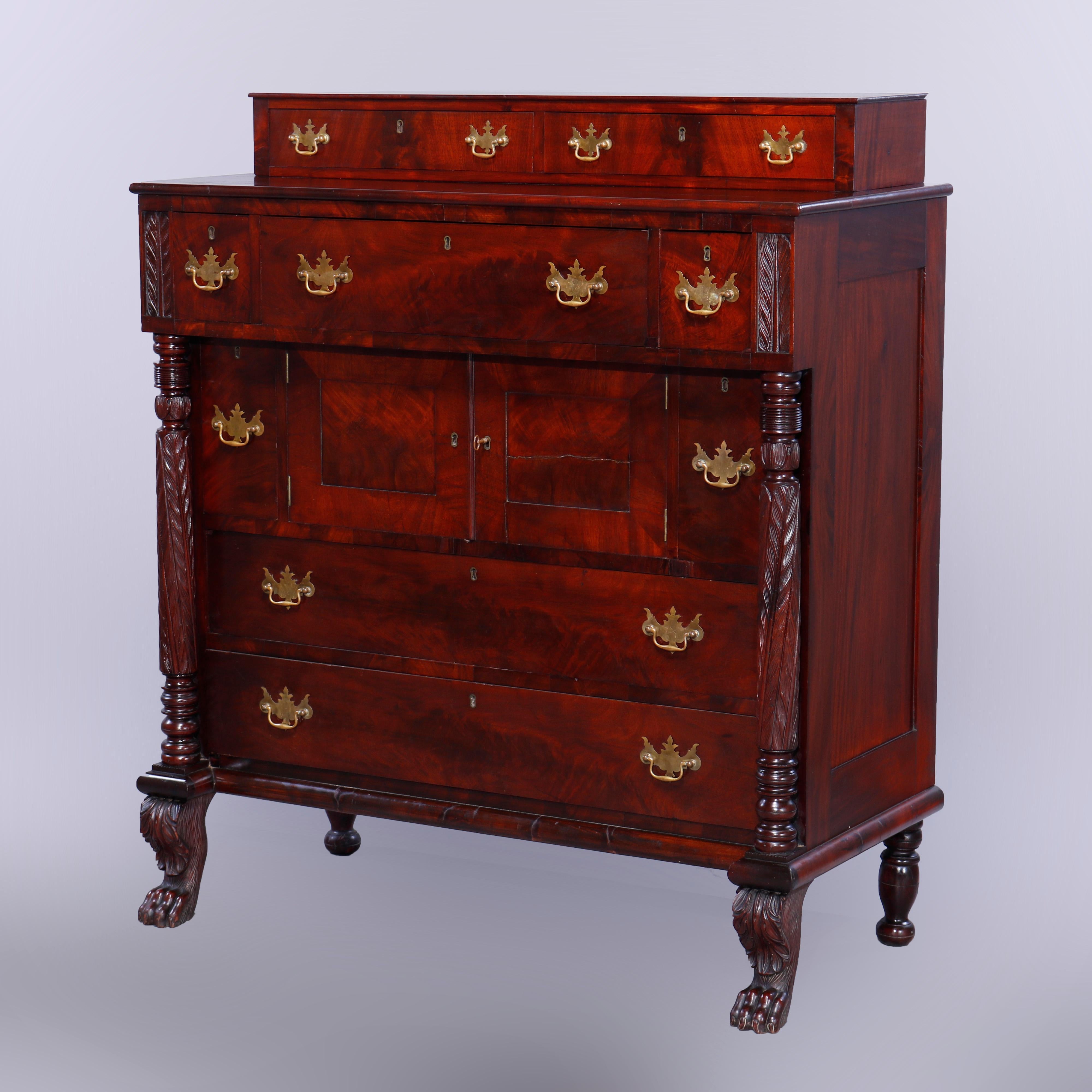 An antique American Empire Classical Grecian server sideboard offers flame mahogany construction with upper drawers over lower case with storage drawers and a cabinet having flanking acanthus carved columns, raised on cabriole legs with foliate