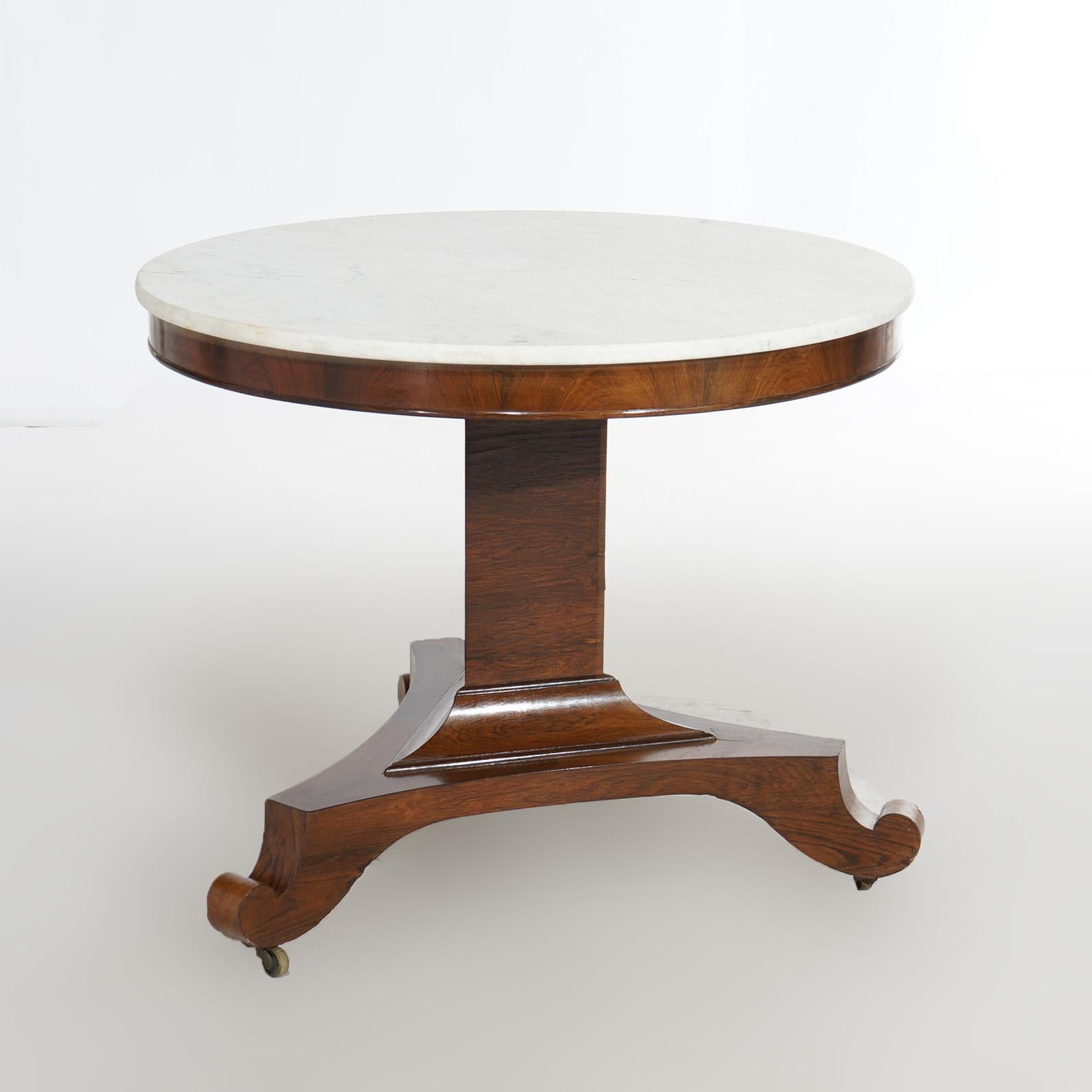 An antique American Empire Classical Greco center table in the manner of Quervelle offers beveled marble op over flame mahogany base having triangular column and raised on three scroll form feet, c1940

Measures- 28.75''H x 34.5''W x 34.5''D