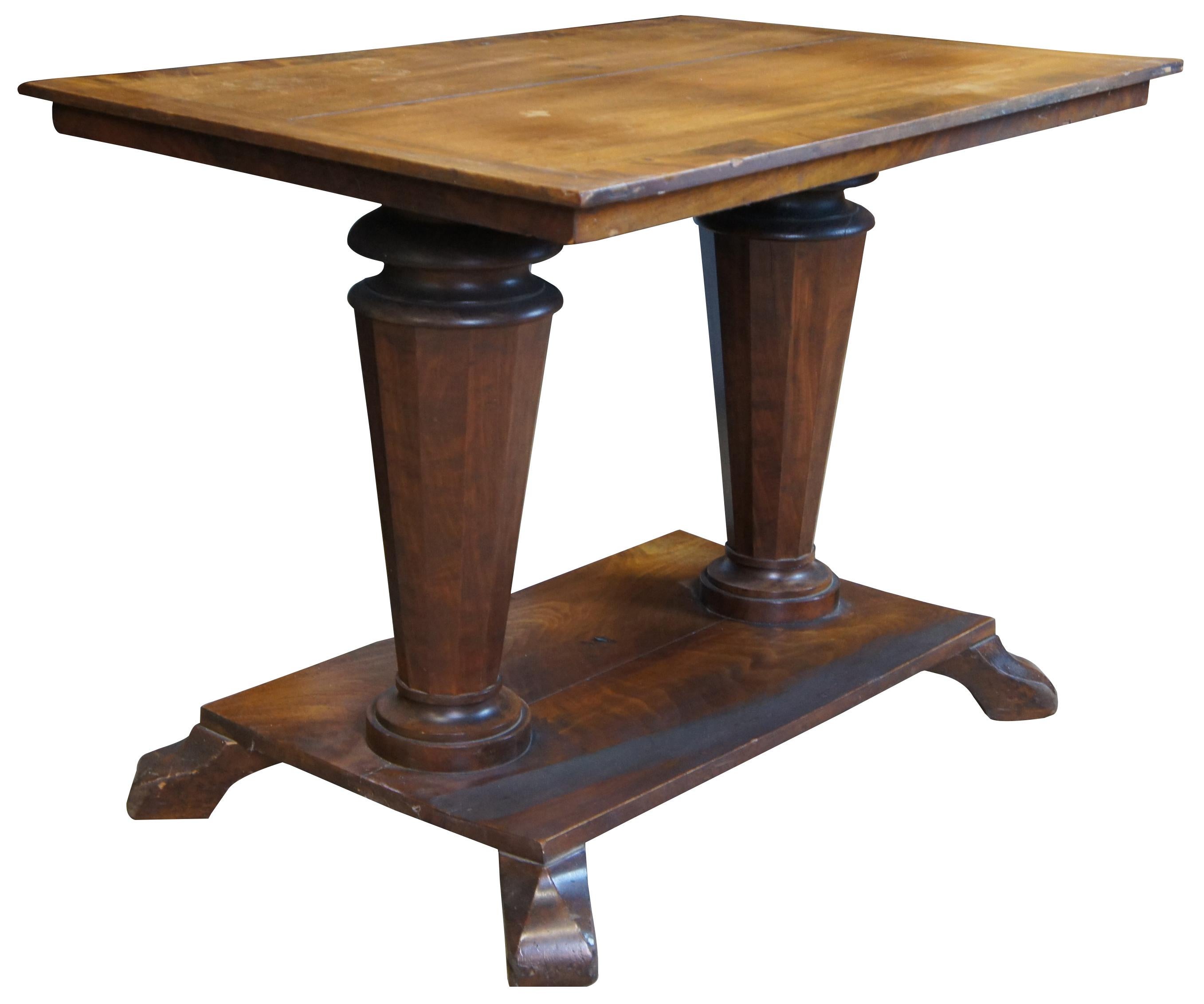 Antique American Empire double pedestal / pillar library table. Made of mahogany featuring rectangular form with two large turned and tapered columns.
 