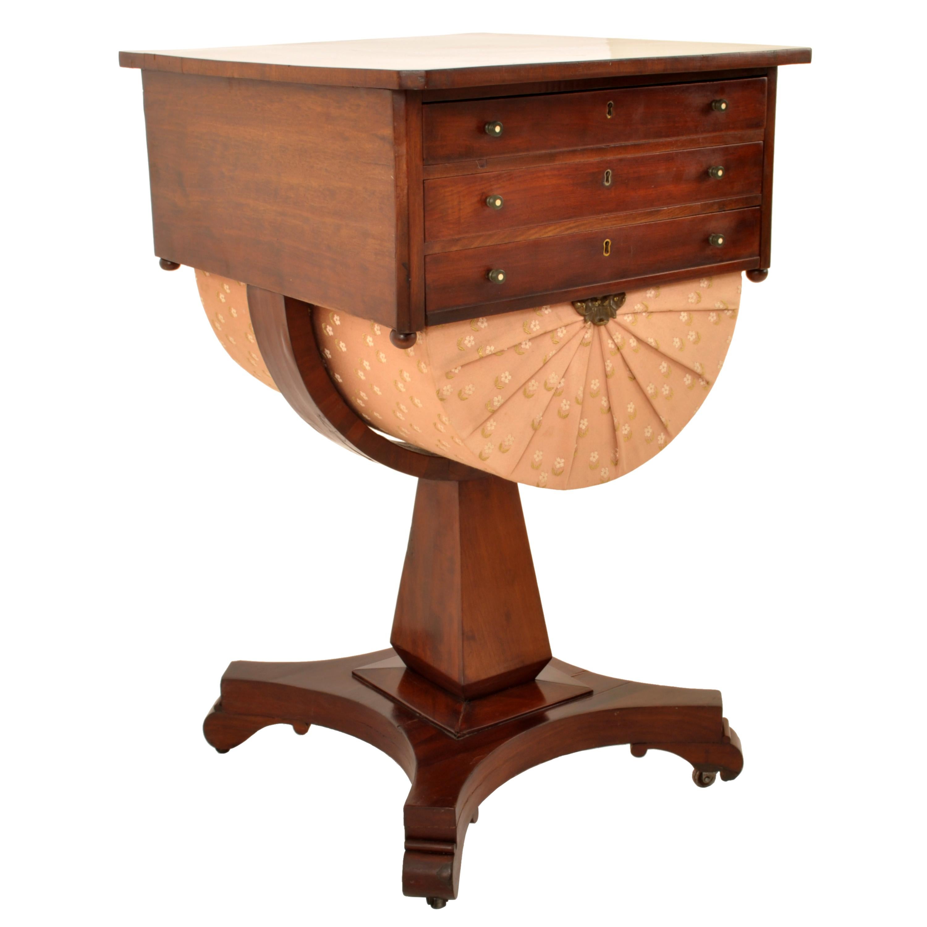 A good antique American Empire period flame mahogany work table, New York, circa 1840.
The table made from flame mahogany and having three drawers, the top with a fitted interior, the third drawer with a pleated satin fabric embroidery 'basket'