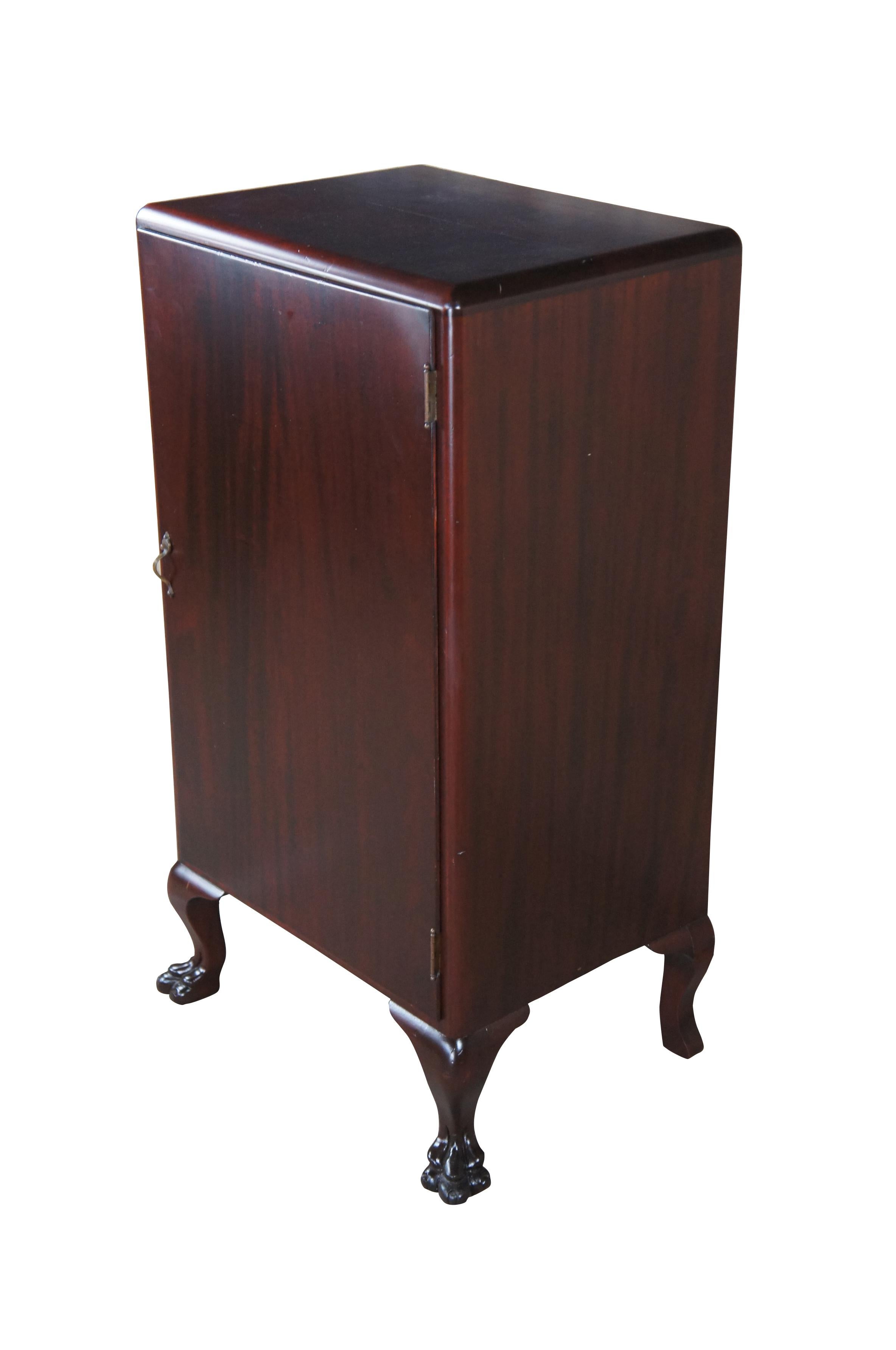 A quaint American Empire mahogany sheet music cabinet, circa 1900s.  Features a rectangular frame over cabriole legs leading to robust claw feet.  Opens via brass handle to three adjustable shelves. Shelves could be configured to accommodate
