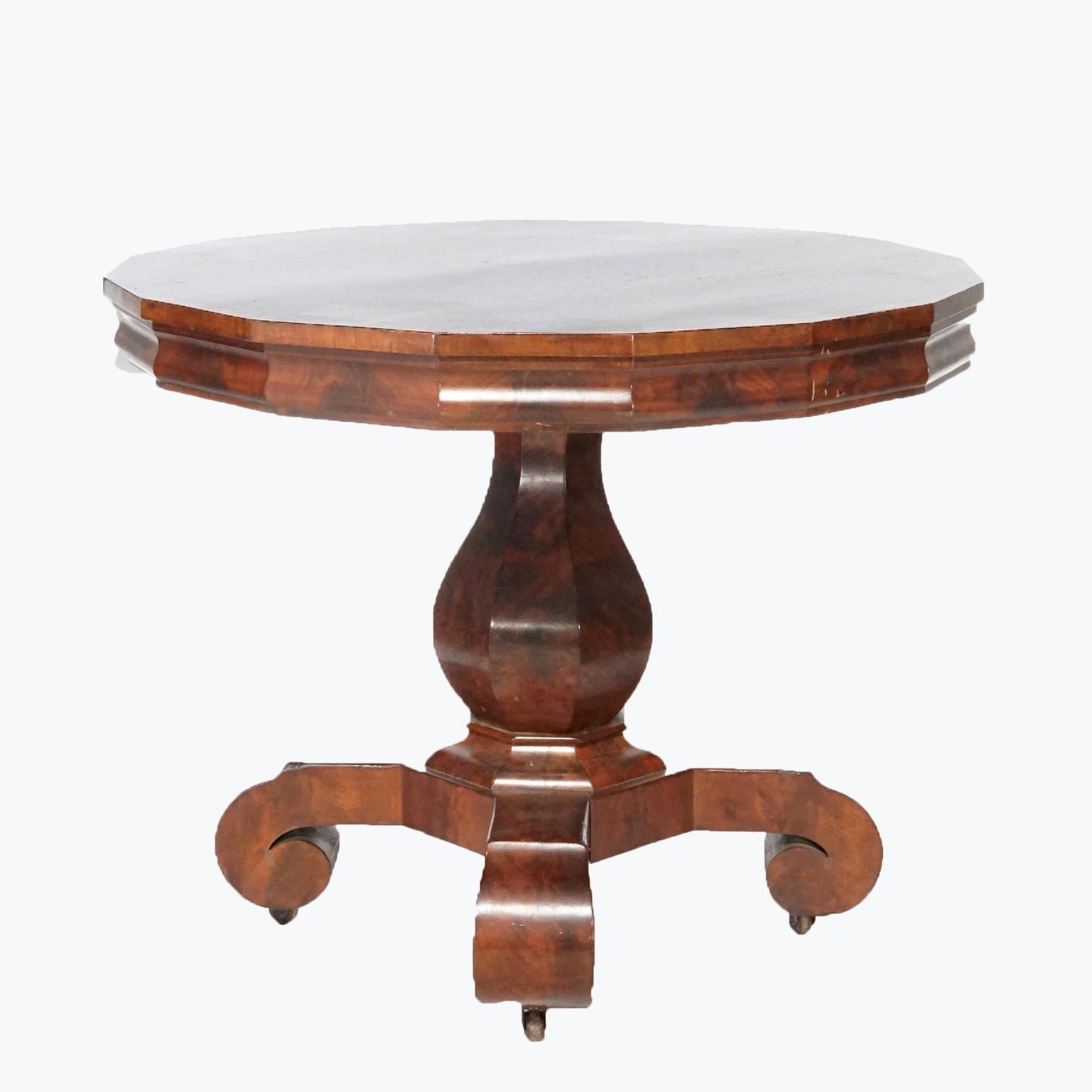 An American Empire center table in the manner of Meeks offers flame mahogany construction with faceted top raised on stylized urn form pedestal with scroll feet, circa 1840

Measures - 28.5