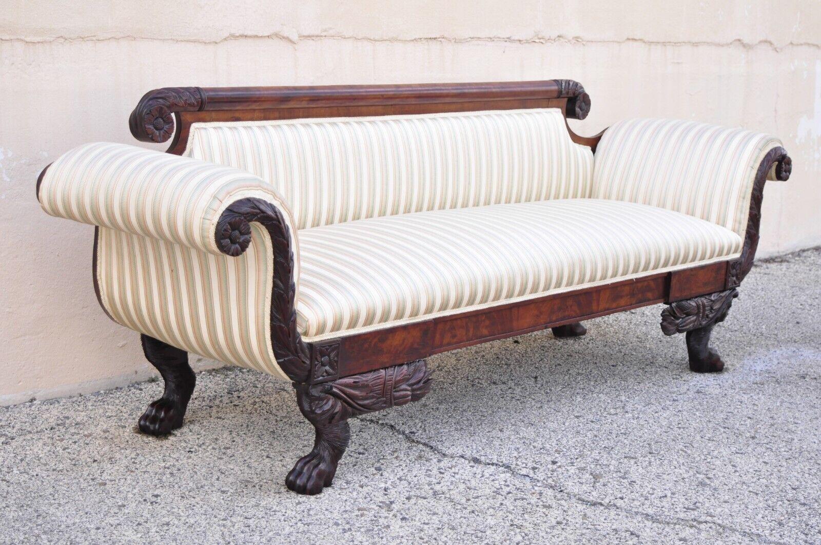 Antique American Empire Regency Mahogany Paw Feet Roll Arm Sofa. Item features hairy paw feet, carved leafy scrolls, rolled arms, solid wood frame, nicely carved details, very nice antique item. Circa 19th Century. Measurements: 31.5