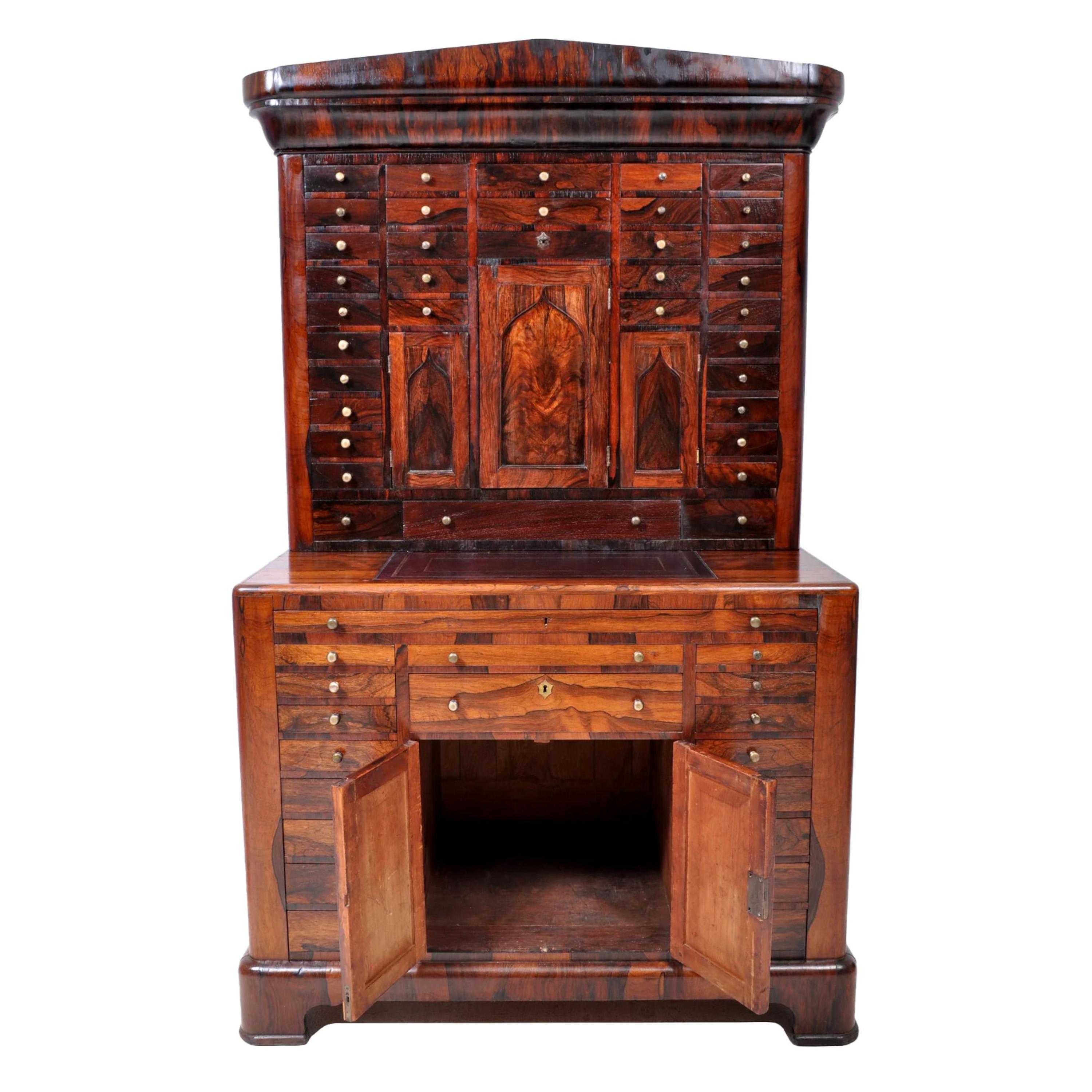 Antiguo gabinete dental / médico de palisandro del Imperio Americano, hacia 1820. Este mueble increíblemente raro, de dos cuerpos, está hecho de palisandro figurado en toda su superficie y tiene un frontón neoclásico en la parte superior. Bajo el