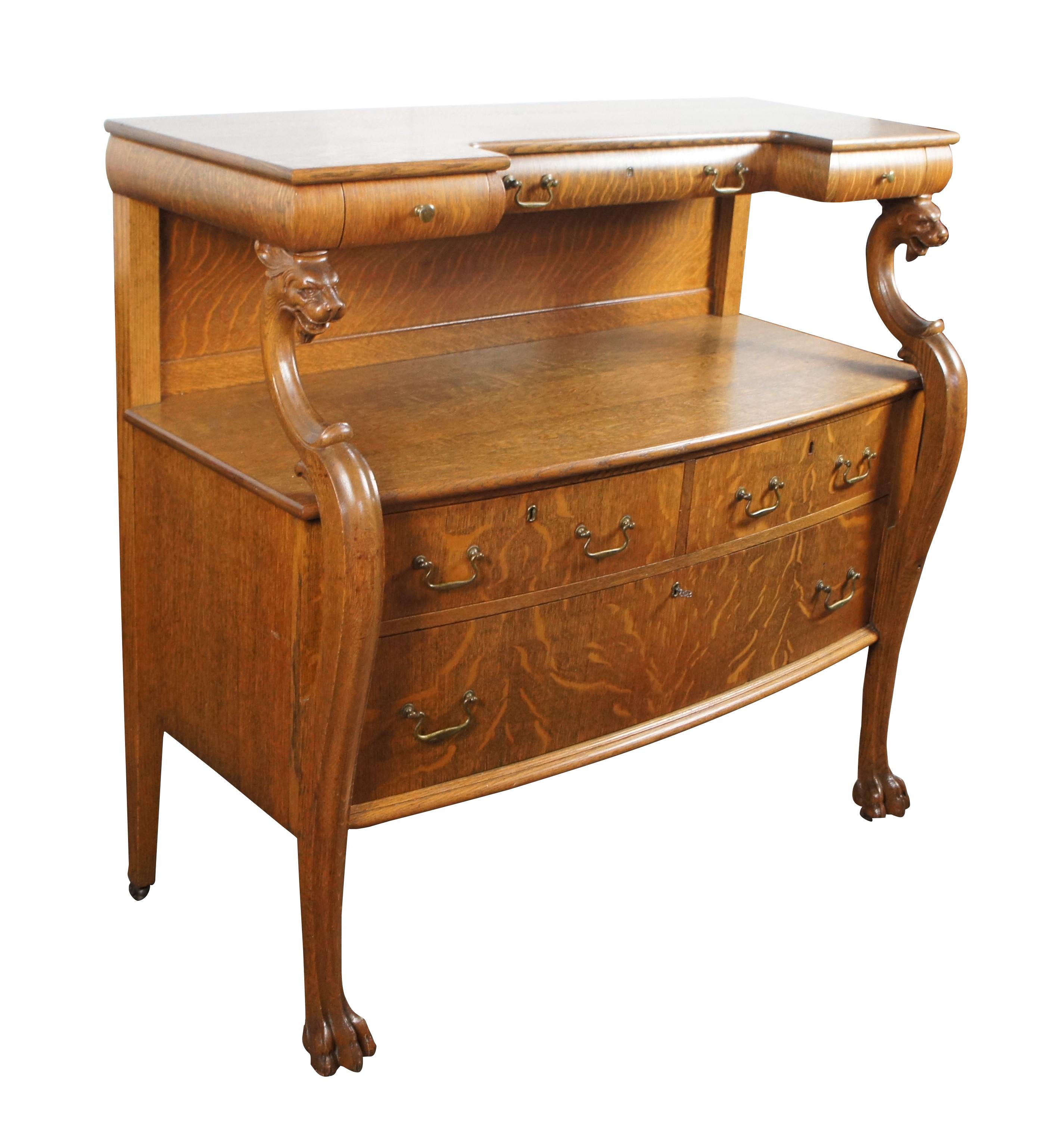 Credenza tardo-vittoriana americana in stile impero, C. 1900.  Ha una forma rettangolare realizzata in quercia segata a quarto con un piano unico tagliato con tre cassetti a coda di rondine all'interno del fregio, sostenuti da teste di grifone o di
