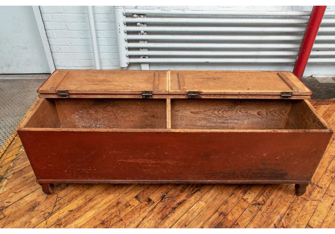 An antique American oxblood painted farm chest in all original condition. A long rectangular chest with hinged lid and divided interior into two compartments. Raised on carved and shaped feet. Suitable for use as a coffee table.
Time-worn original