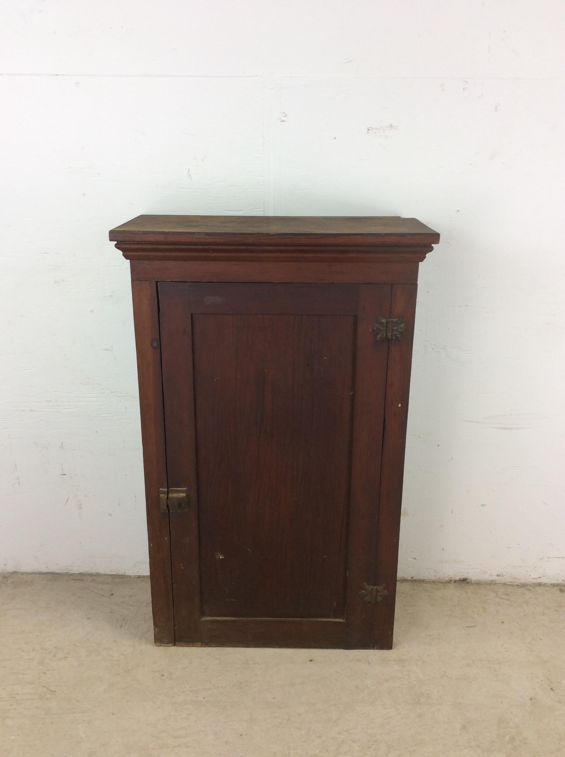 This antique American wall cabinet features pine construction, door with brass latch, and four interior shelves.

Dimensions: 24w 11.5d 37.25h  

Condition notes: Exterior finish has some staining on the top (see photos). Scuffs and scratches