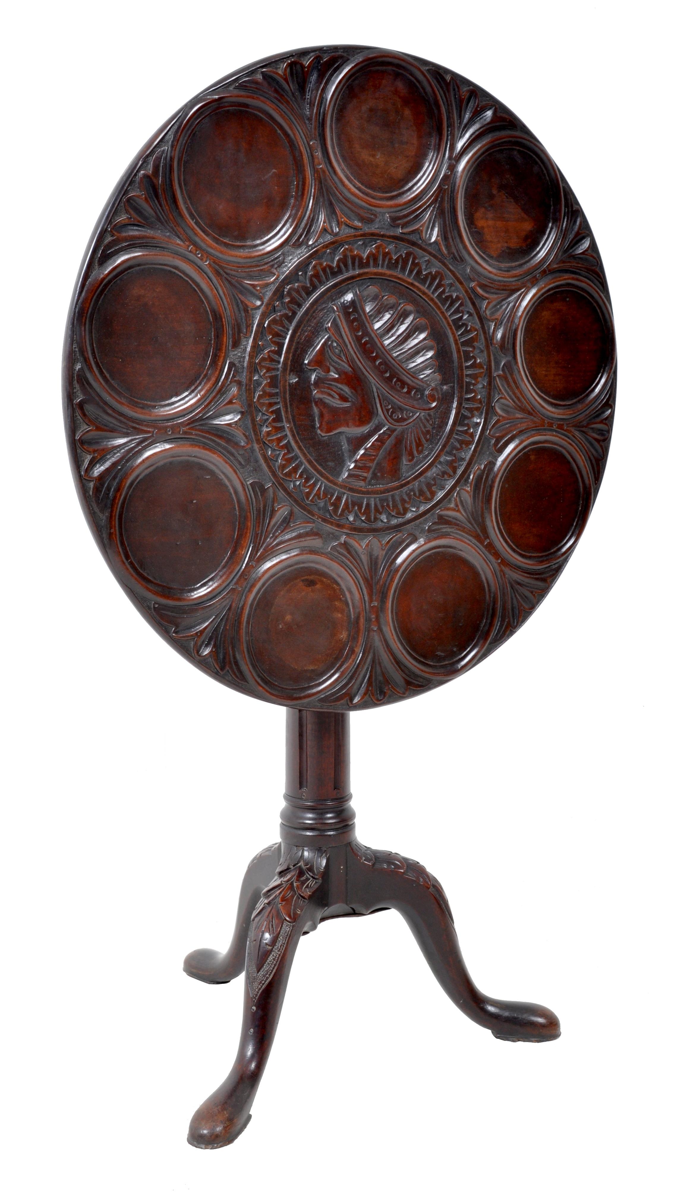 Antique American Federal mahogany tilt-top supper table, circa 1790. Very rare antique American supper table, most likely mid-Atlantic states, carved with a Native American head to the center with nine recesses for plates. The tilt-top standing on a