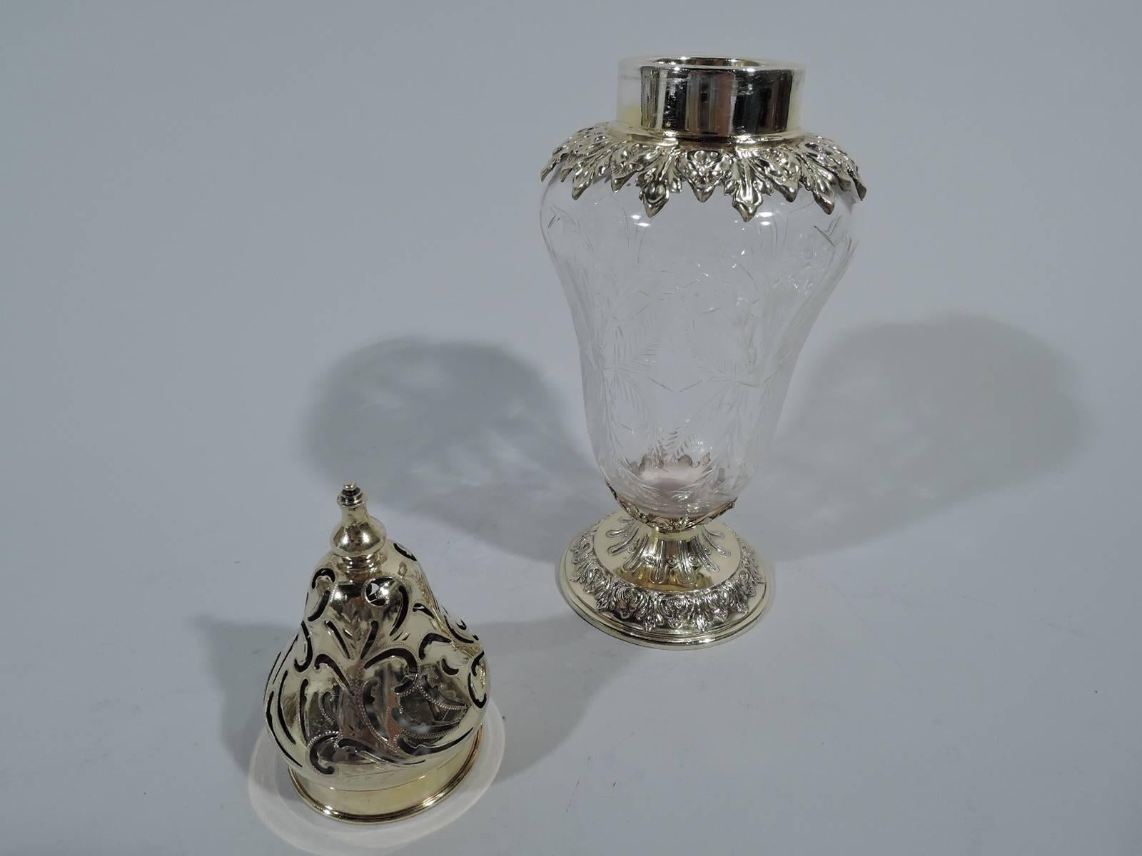 Sumptuous gilt sterling silver and crystal sugar shaker. Made by Black, Starr & Frost in New York, circa 1910. Curved and tapering crystal body with etched ornament. Gilt sterling silver mounts: Short collar with leaf-and-dart surround and domed