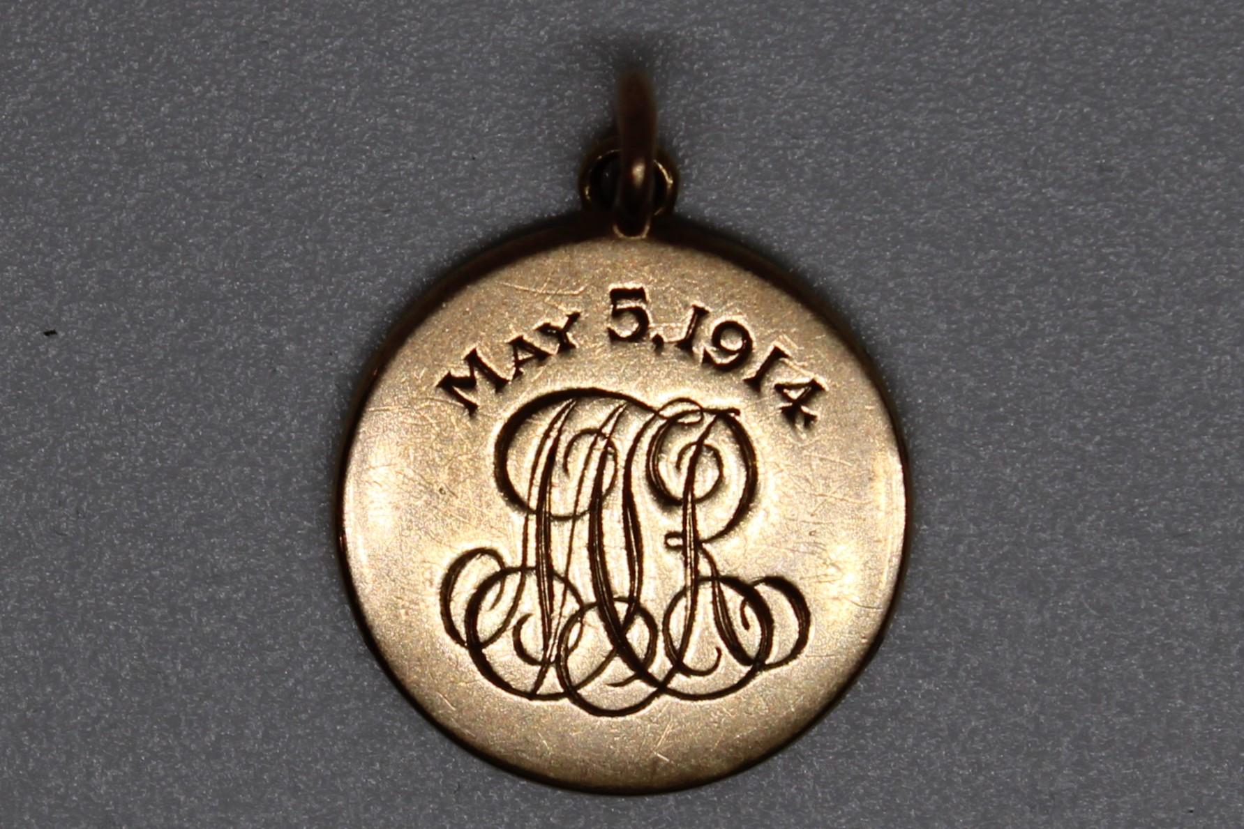 Questo eccezionale amuleto circolare di piccole dimensioni, realizzato in ricco oro americano, emana un'eleganza senza tempo. Progettato per essere portato vicino al cuore, è dotato di un anello lucido nella parte superiore per essere agganciato in