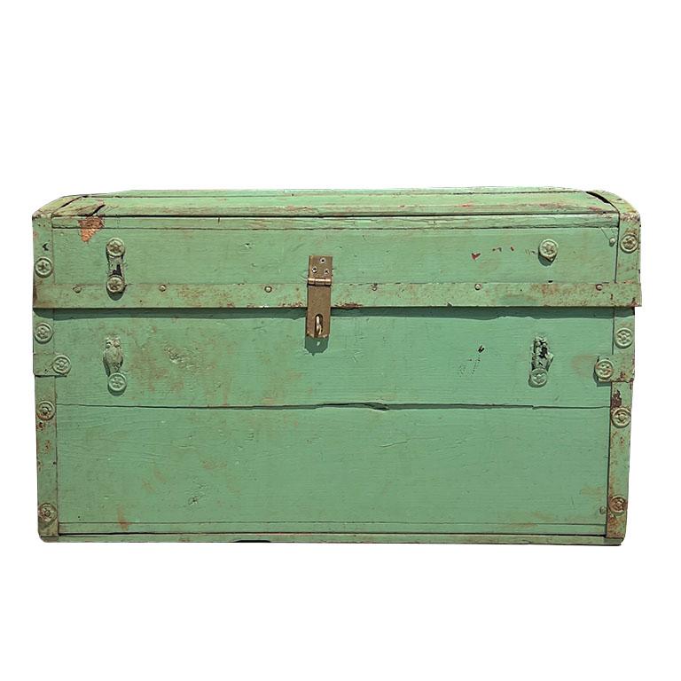 An early 19th-century American wood steamer trunk. A fabulous antique trunk painted in a muted green. Created from wood, the sides are reinforced with wood and metal clasps. Metal handles fank each side. The interior of the trunk is covered in