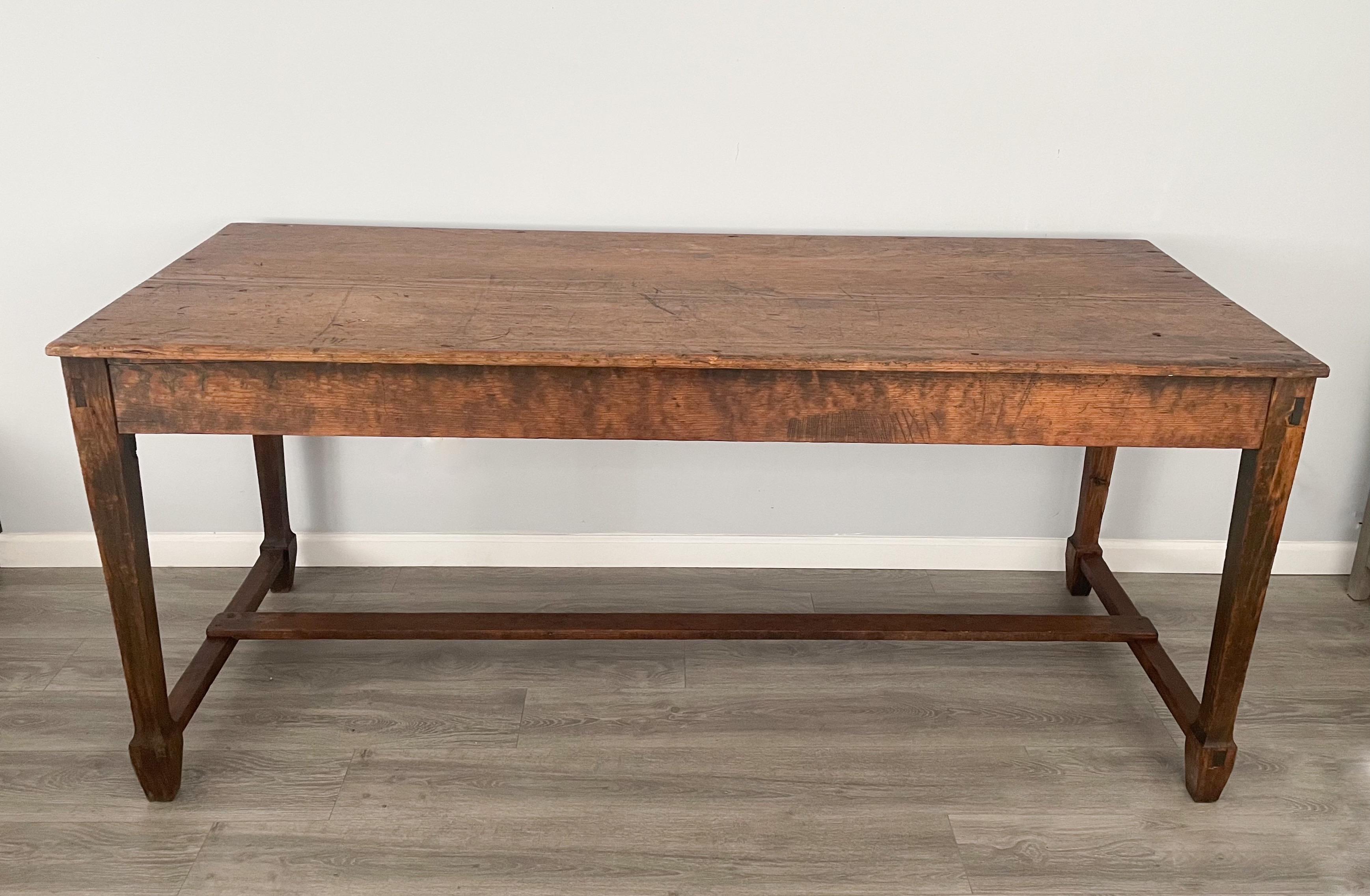The table consists of a table top made from a single slab of wood. The base is constructed of mortise and tenon joinery, and a center stretcher. 

 The table show wear consistent with it’s long utilitarian history, it is however sturdy and strong,