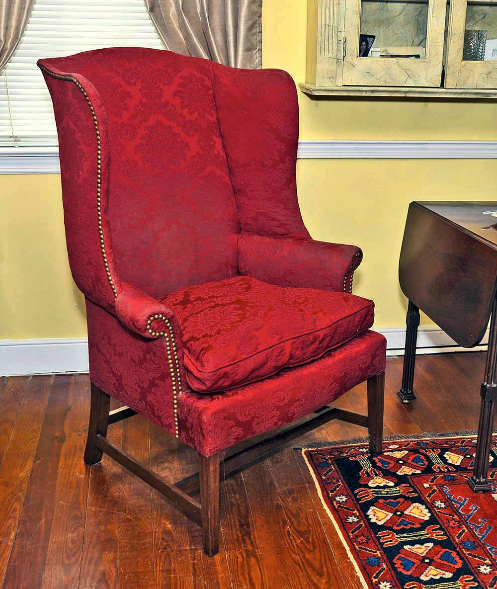 This American period wing chair is cherrywood with a maple and tiger maple frame. The tapered and moulded front legs are joined with a dovetailed stretcher. It retains much of its original 18th century upholstery materials and was photographed prior