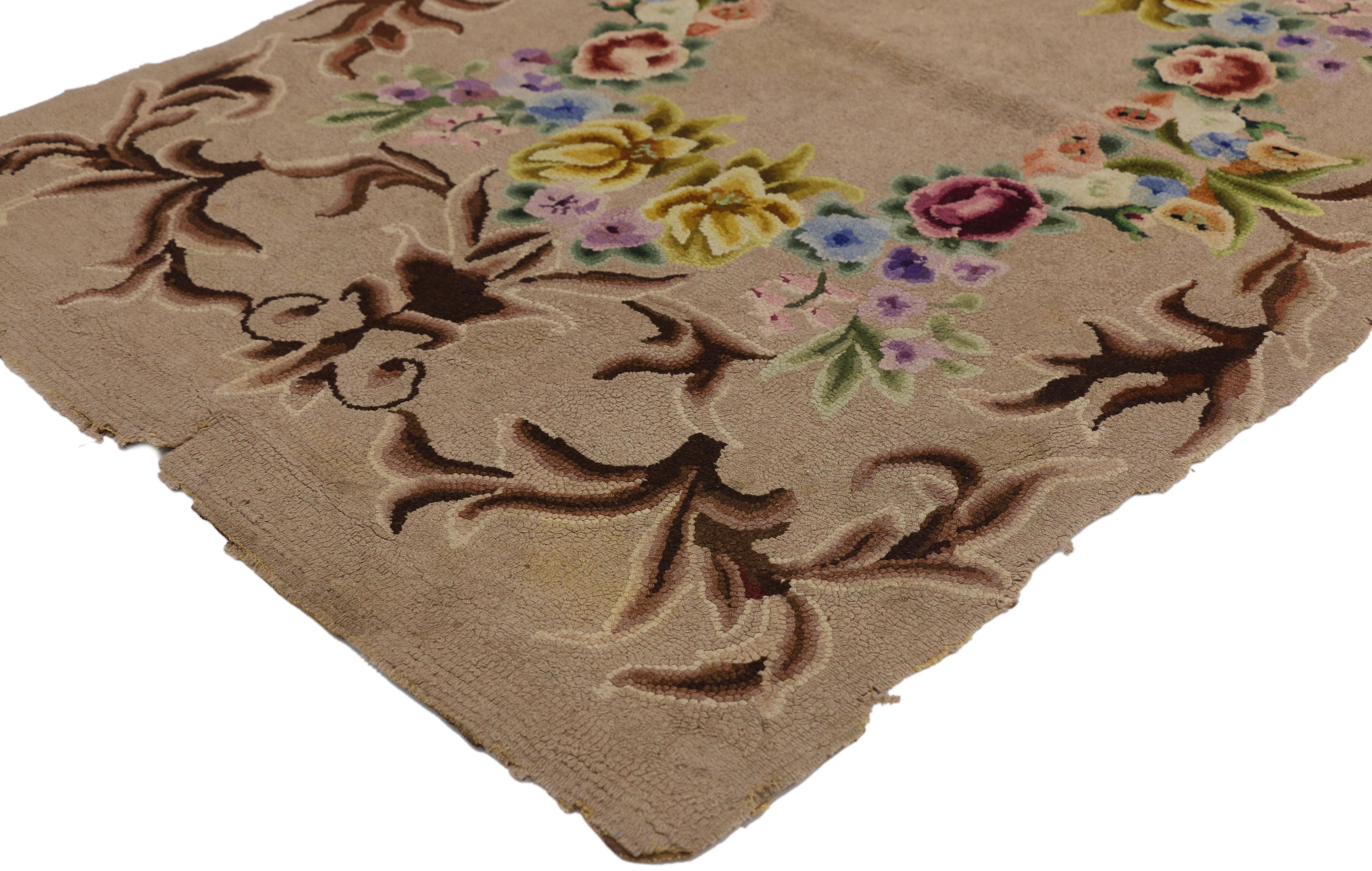 74345 Antique American Hooked rug with French Aubusson style. This antique American hand hooked rug with French Aubusson style features a decorative round floral wreath with an open center. The floral wreath is flanked out the outside with a brown