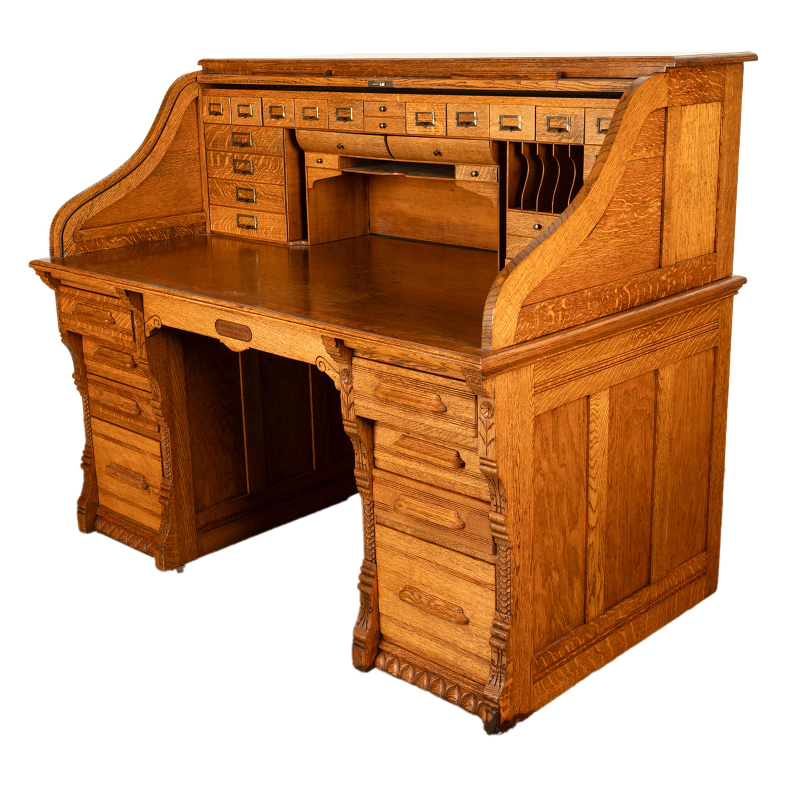 A good, large antique American roll top oak desk, by the Indianapolis Cabinet Company, circa 1890.
This very high quality desk is made from solid quarter-sawn oak, the 'S' curve roll top opens and close with ease and encloses an extravagantly fitted