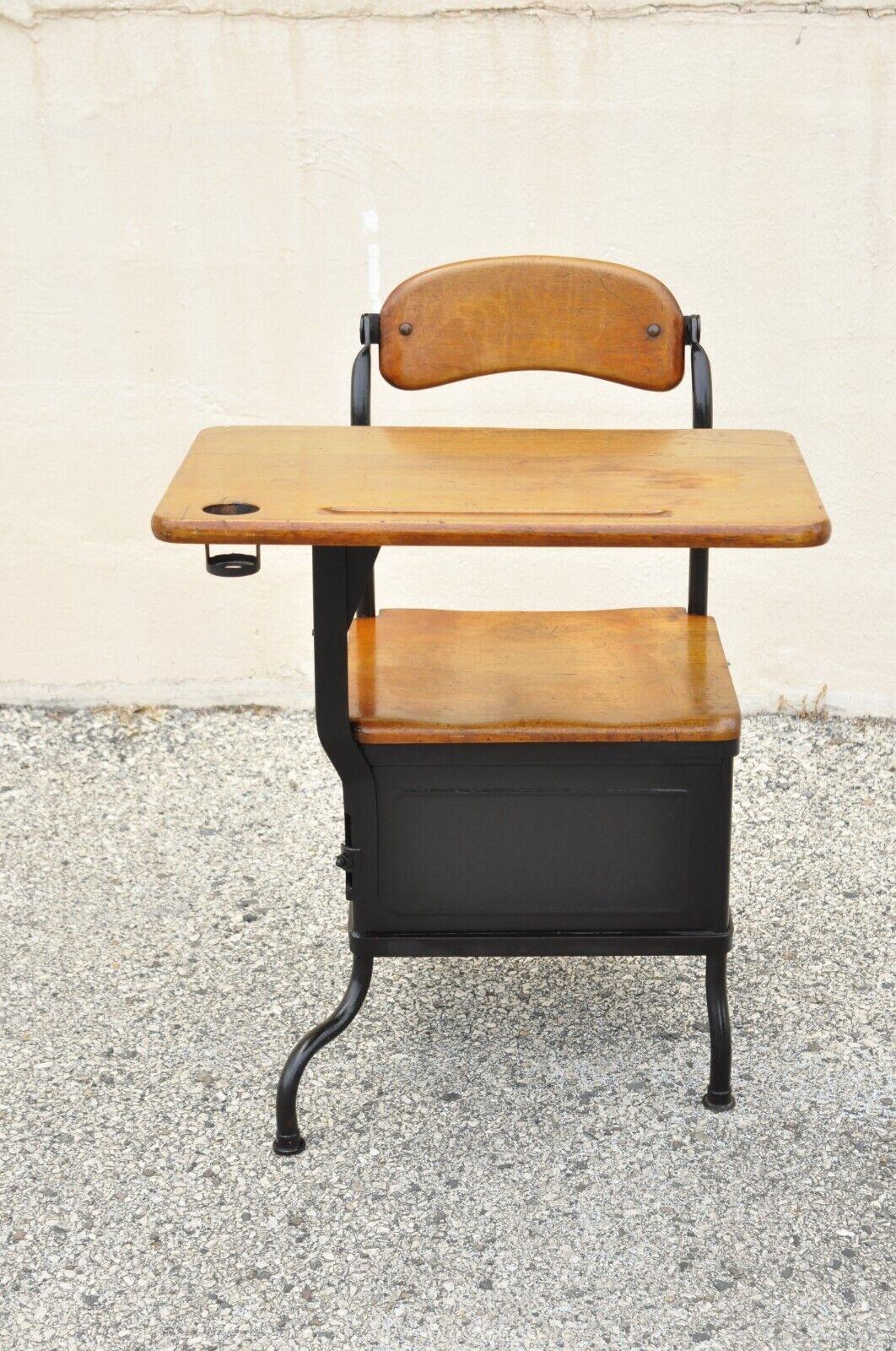 Antique American industrial iron and maple childs school writing desk. Item features a lower cubby storage to side, iron frame, pivoting backrest, very nice antique item, quality American craftsmanship, great style and form. Circa early 20th