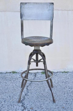Ancien tabouret de travail industriel américain en métal avec assise en chêne et canne