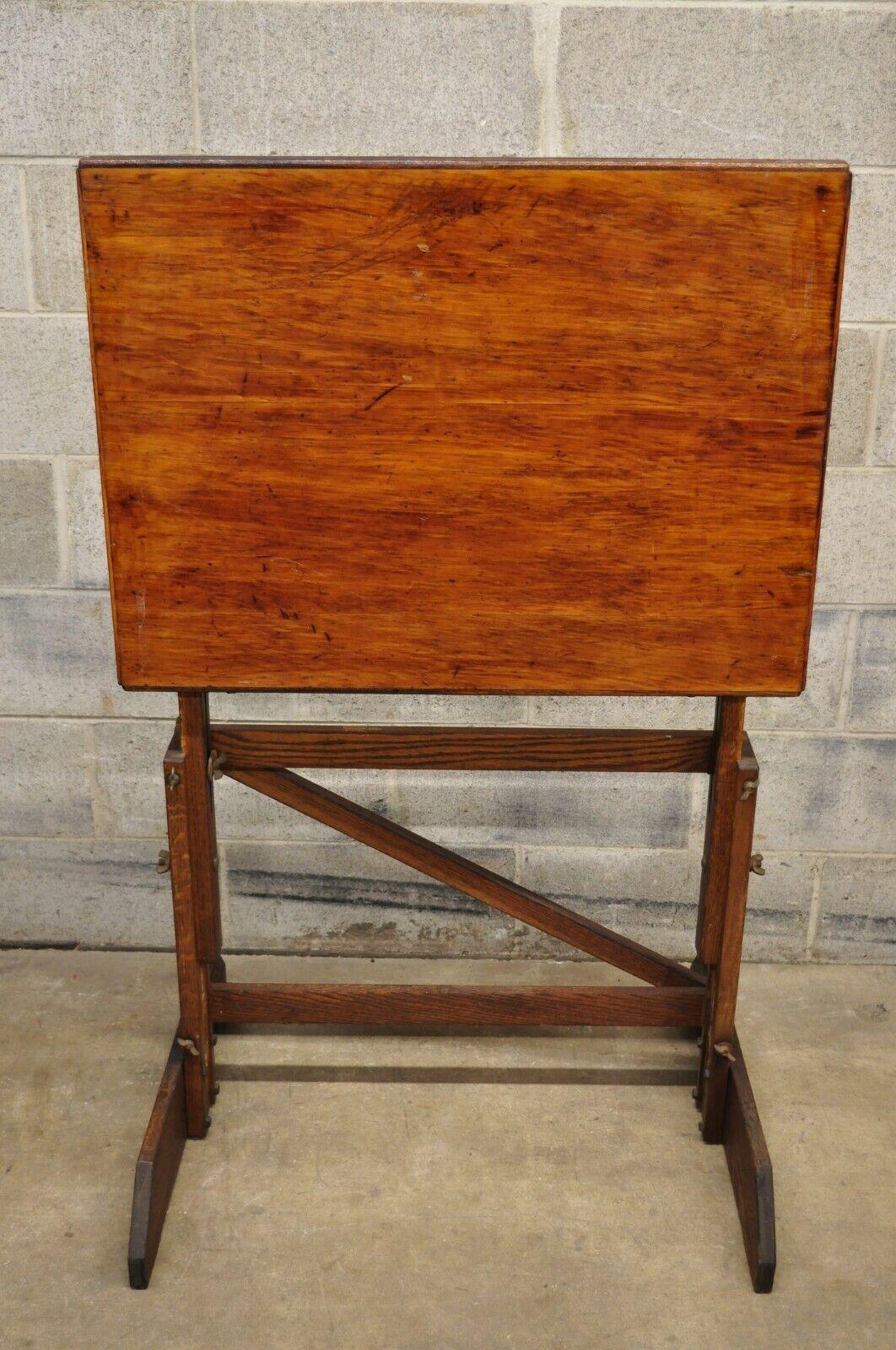 Antique American Industrial oak wood adjustable artist drafting table work desk. Item features a pivoting top, adjustable height, solid wood construction, beautiful wood grain, very nice antique item, great style and form. Circa Mid 20th Century.