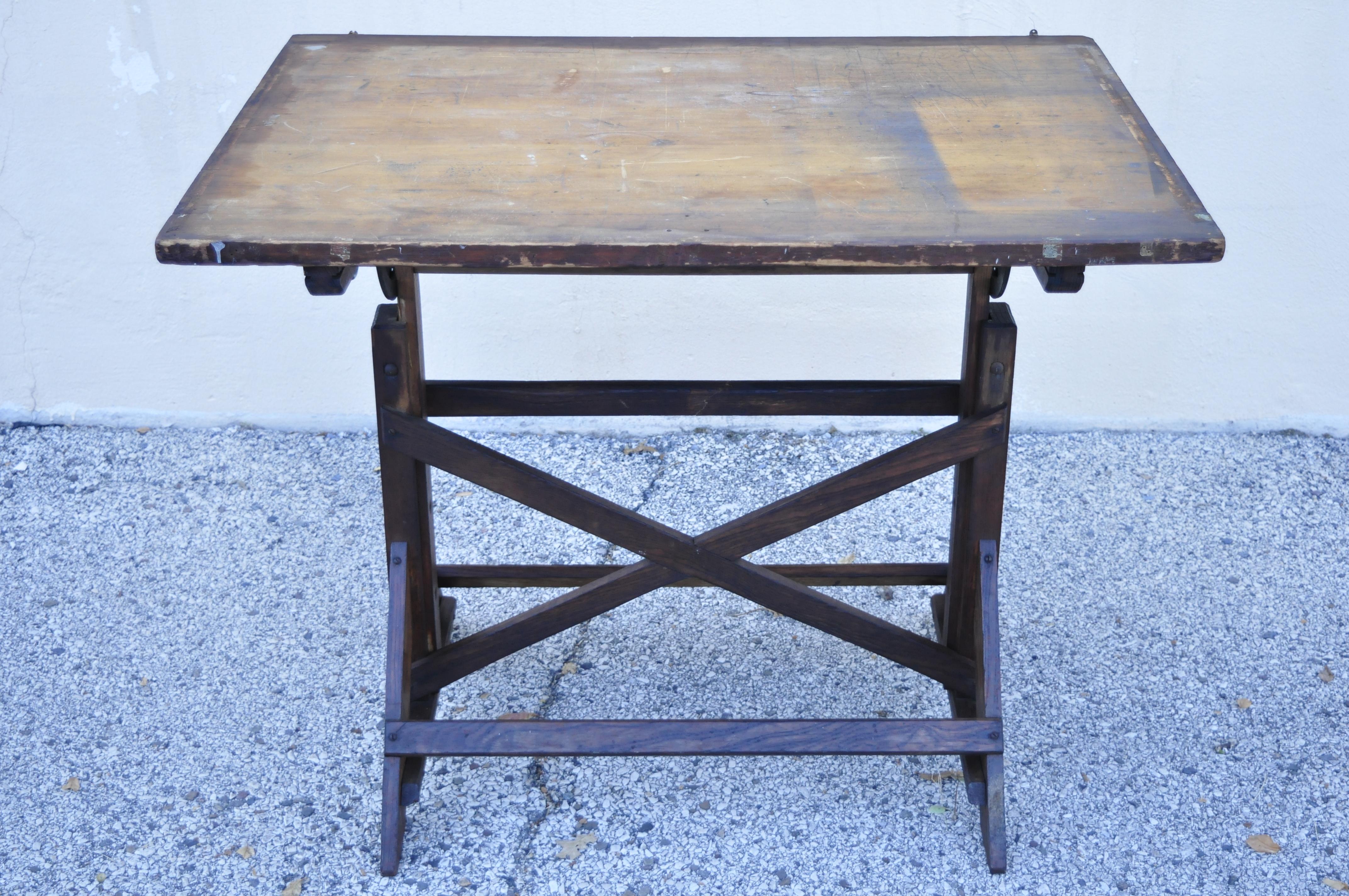 Antique American industrial oakwood and cast iron drafting table work desk. Item features cast iron hardware, adjustable height, solid wood construction, beautiful wood grain, distressed finish, very nice antique item, circa early 1900s.