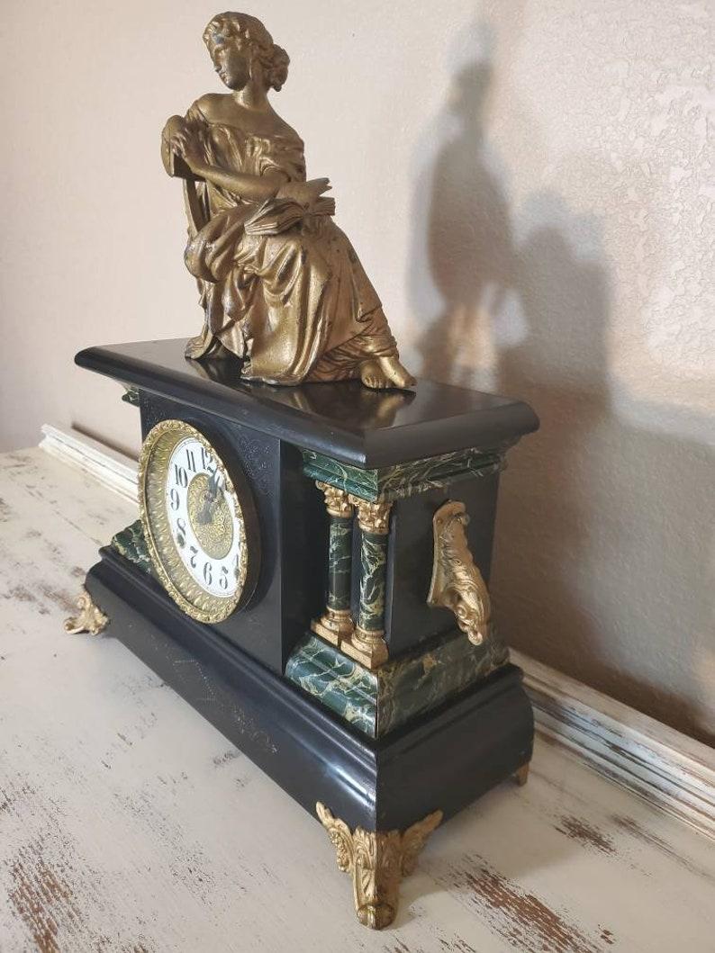 A spectacular American antique mantel shelf clock, by Ingraham Clock Company, Bristol, Connecticut (1831-1958). 

This early 20th century, architectural faux marble black enameled case, richly decorated in classical style including verde green