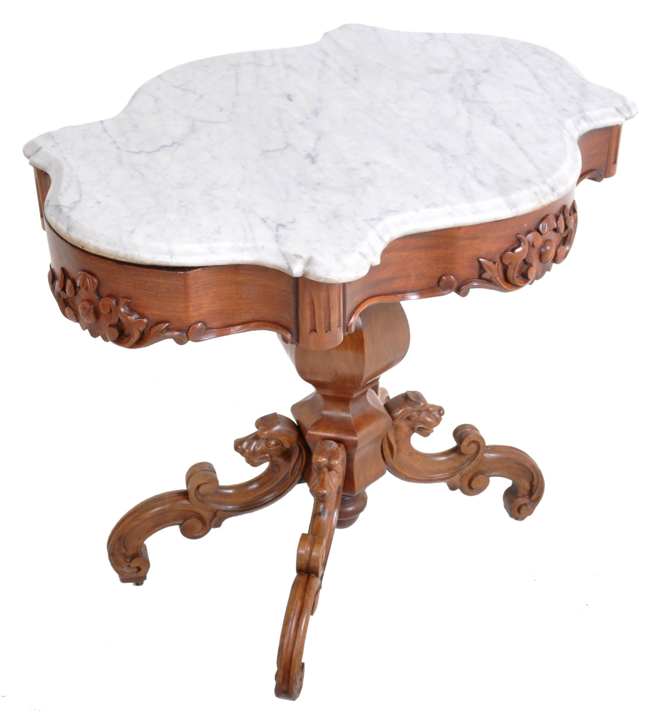 Antique American Victorian walnut marble-top parlor table, possibly John Henry Belter or Joseph Meeks, circa 1860. The finely carved table having a turtle shaped Carrara marble top, the skirt carved with foliate design on four sides. The table