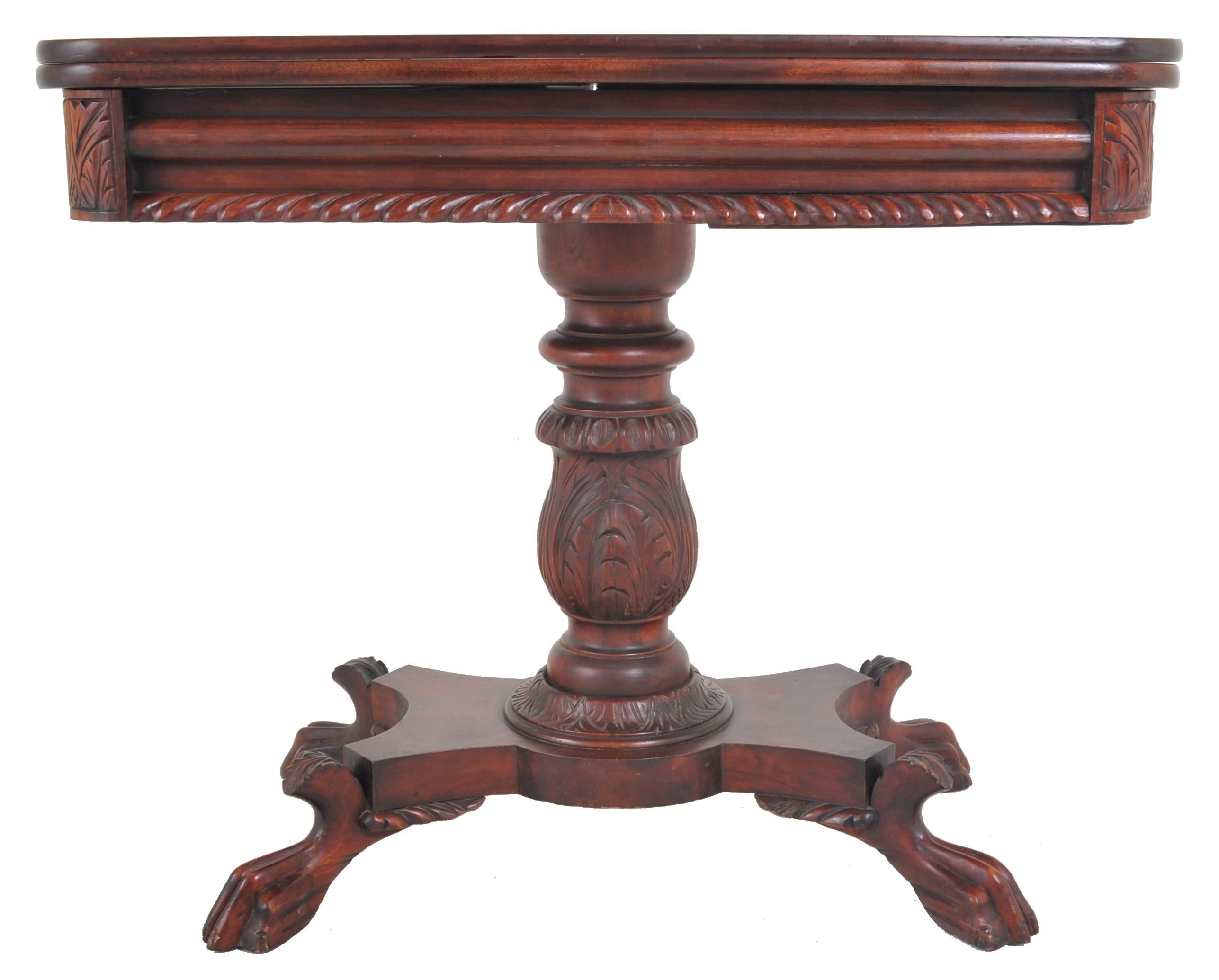 American late federal/empire mahogany fold-over tea/games/card table, circa 1830. The table having a fold-over & swivel top, below is a carved and gadrooned skirt. The table standing on a turned and carved pedestal with four Zoomorphic feet. Most