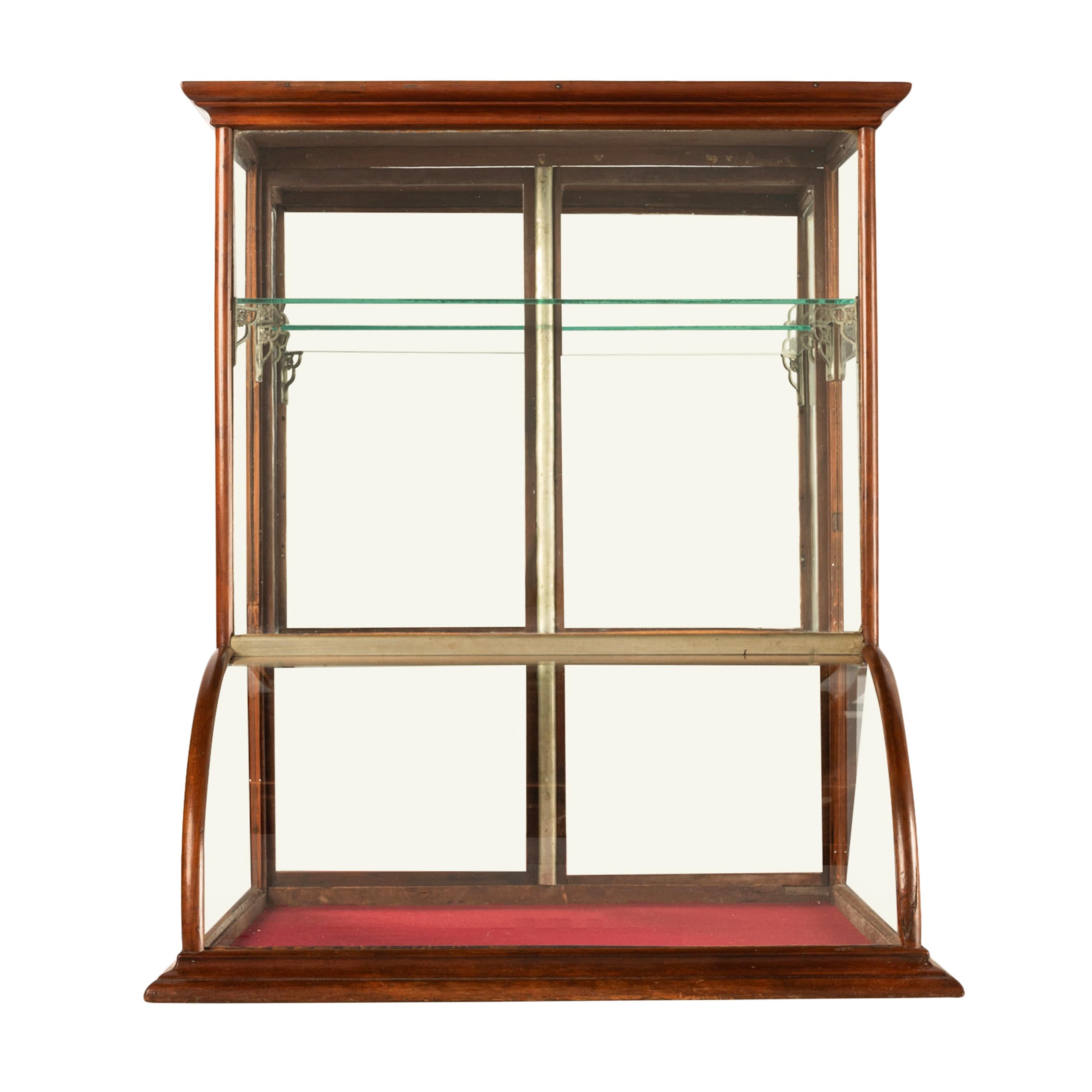 A very good antique American oak and curved glass mercantile counter top display case, circa 1900.
The display case having a stepped crown & a pair of doors to the rear with the original locking latches, to the interior are two glass shelves, the
