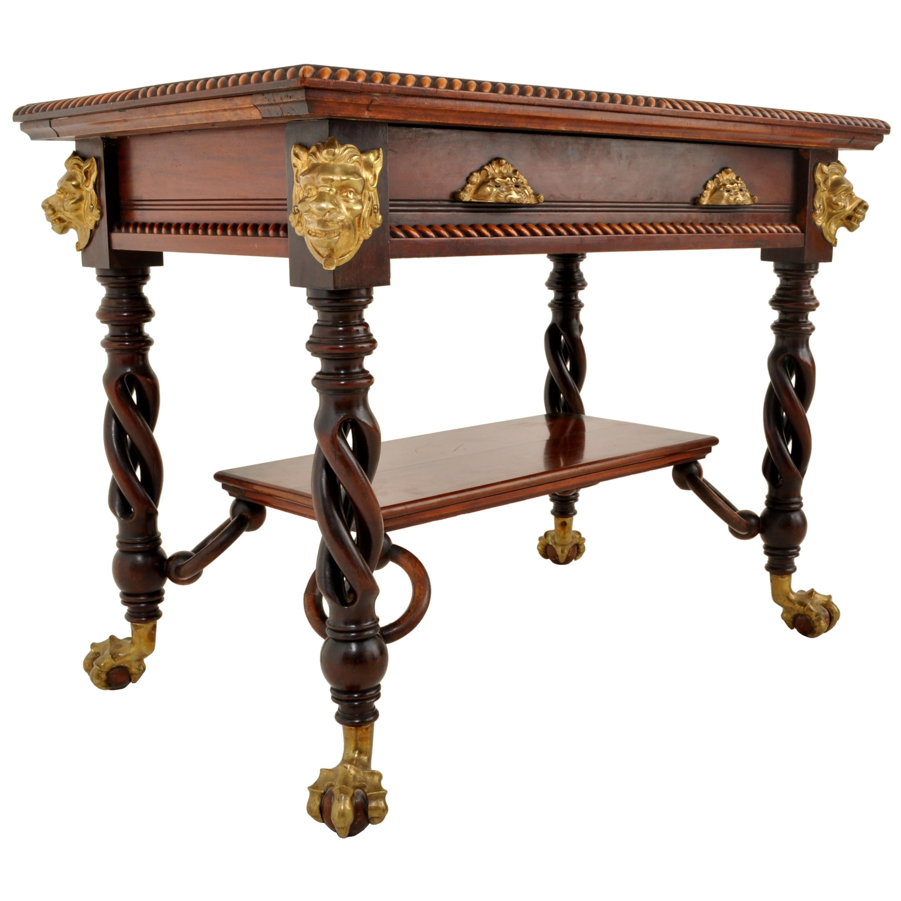 An exceptional antique American walnut library/writing table, by Merklen Bros of NYC, circa 1885. The table having a gadrooned top, with a single drawer to the front fitted with the original brass pulls cast as grotesque masks, the table having a