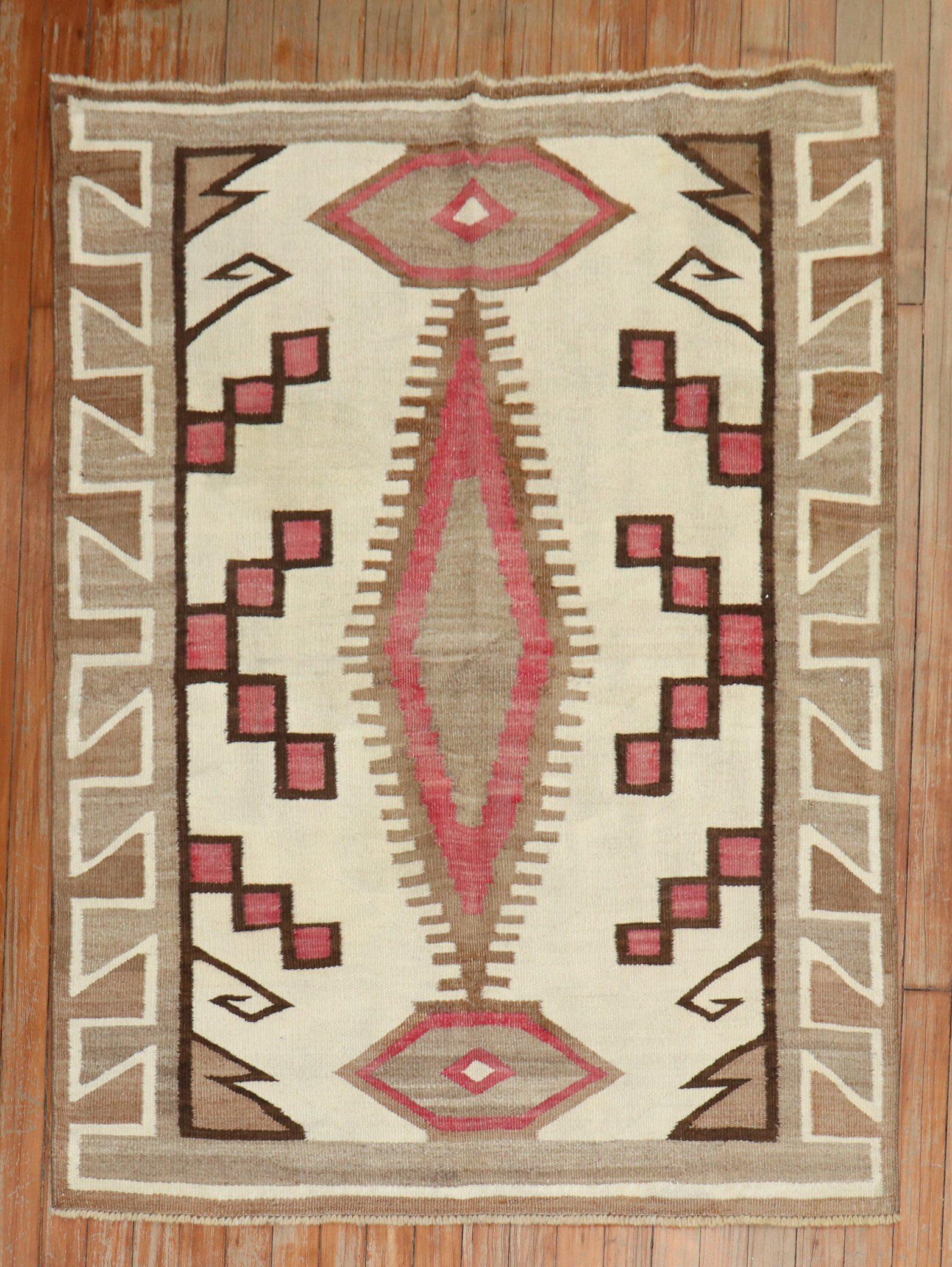 A highly decorative 20th-century American Navajo Rug with a geometric tribal design with pink, camel and brown accents on an ivory field.

Measures: 3'5'' x 4'5''.
 