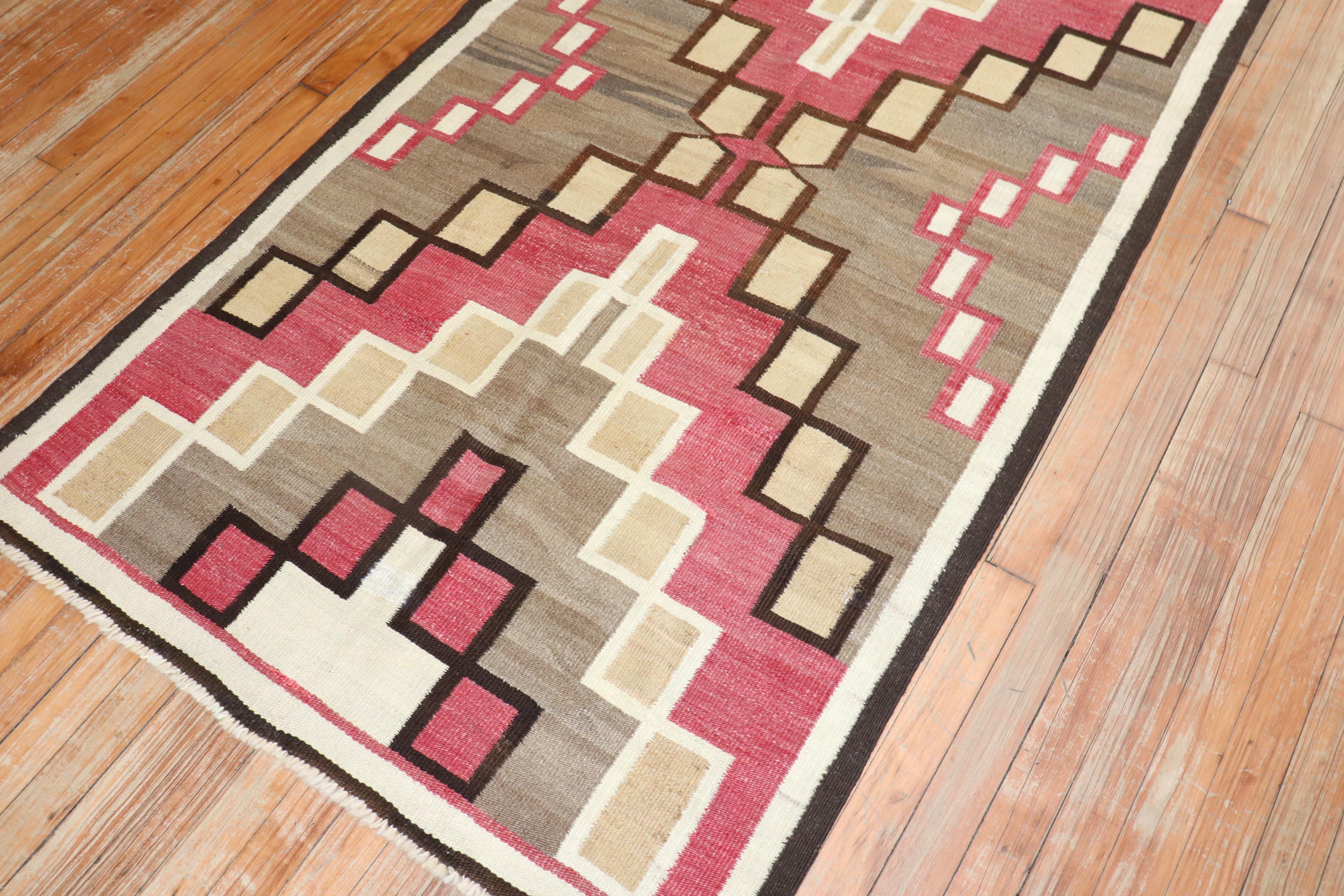 A highly decorative 20th-century American Navajo rug with a geometric tribal design with pink, cream ,camel and brown accents 

Measures: 3'5'' x 6'2''.
