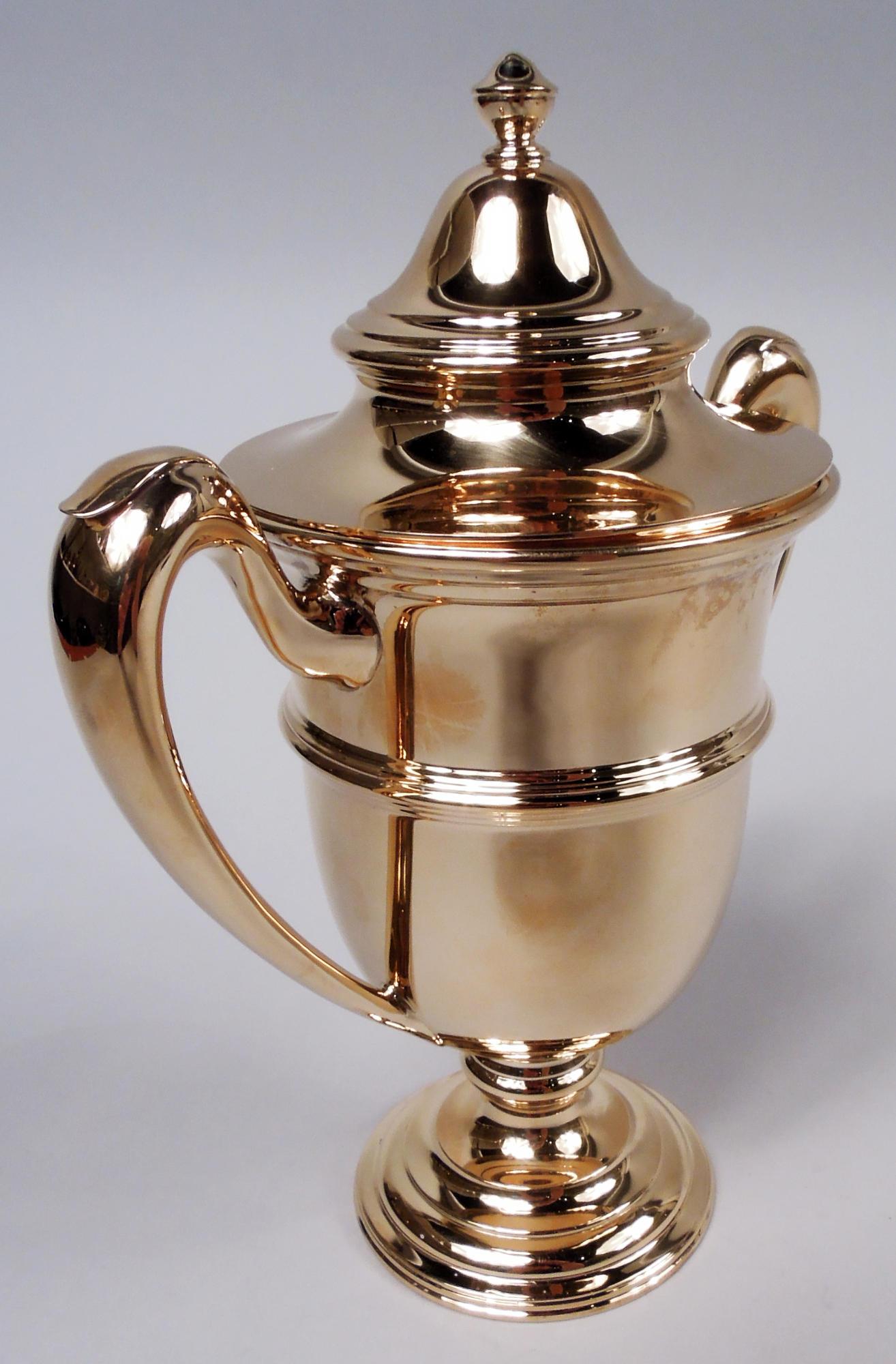 Urne couverte néoclassique américaine de style édouardien 14k, vers 1910. Forme traditionnelle avec un bol ovoïde ceinturé, des poignées latérales coiffées, et un pied à gradins et bombé. Couvercle bombé avec fleuron vasiforme. Beaucoup d'espace