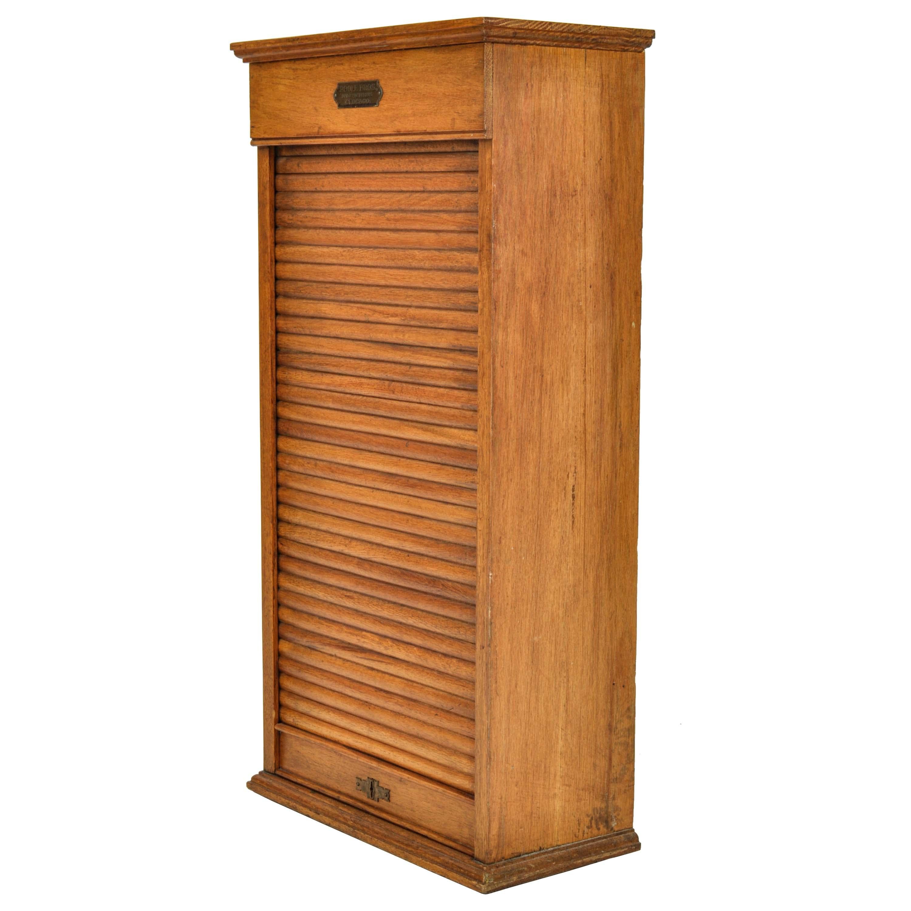 Antique American oak roll/tambour top Railway ticket cabinet, circa 1920, by Poole Bros., of Chicago.
The cabinet having a locking tabour roll, that runs free and smooth, enclosed are a series of shelves to store railway tickets. The base has a
