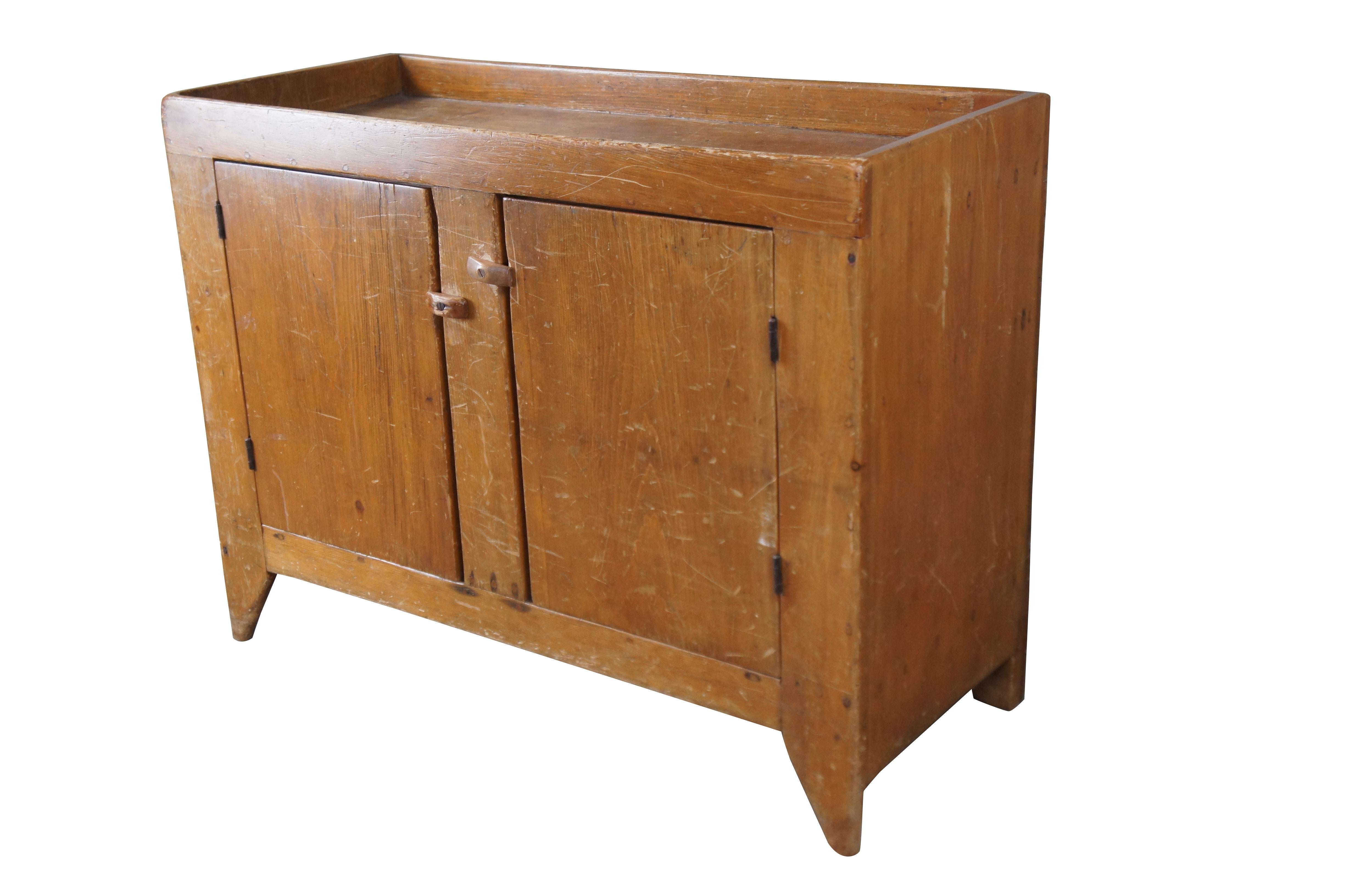 Antique American farmhouse dry sink. Made from pine. Features a large basin over a lower cabinet with shelf for storage. Great for use as a pantry, changing station or dry bar.

Dimensions:
41