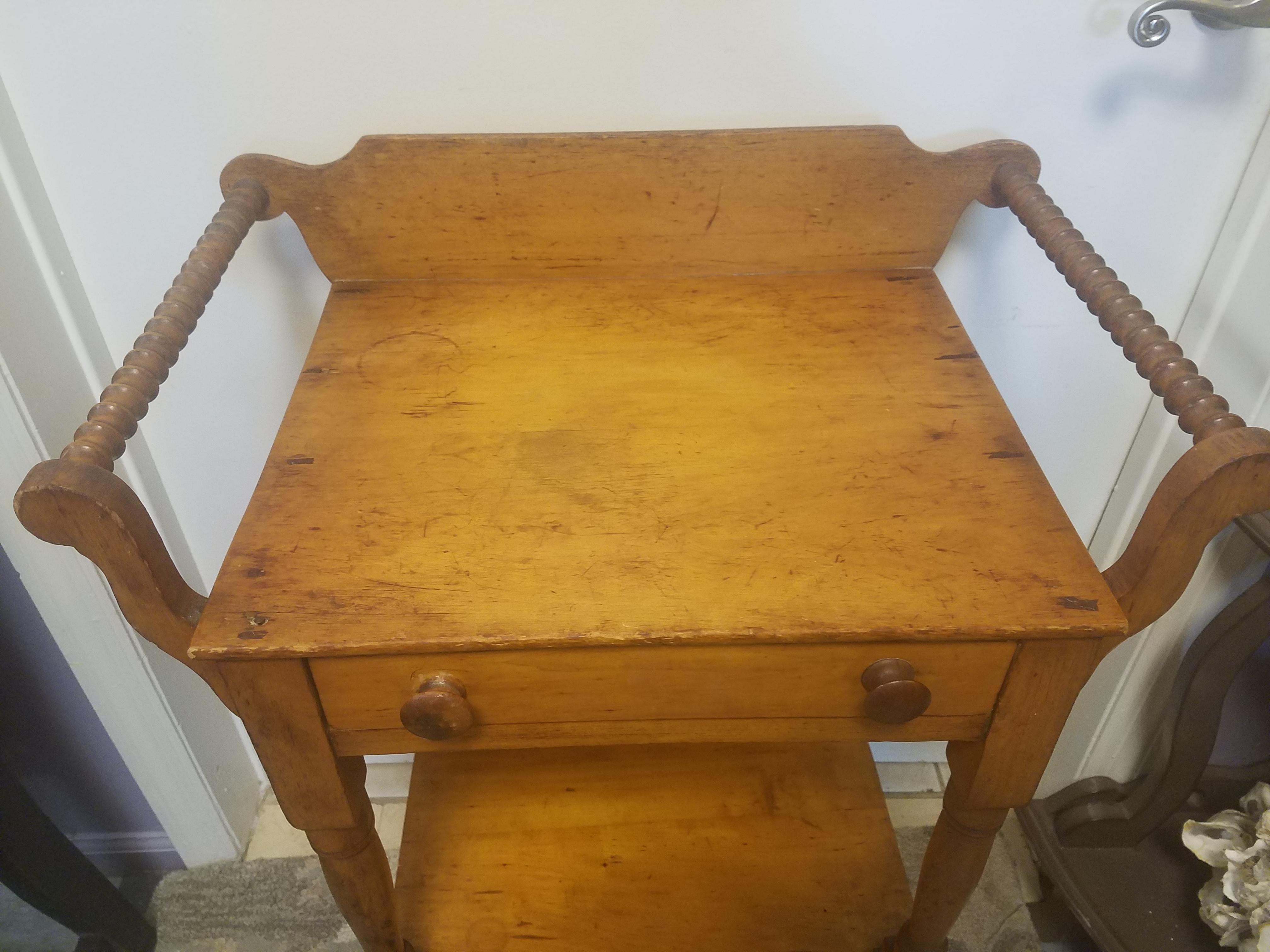 Antique American oak. Hand-turned spindle accents on the two sides. See detailed picture. Very rustic and shows many signed of use. There is a chip on the back (see last picture). There are two different wood pulls. From the Pennsylvania area of the