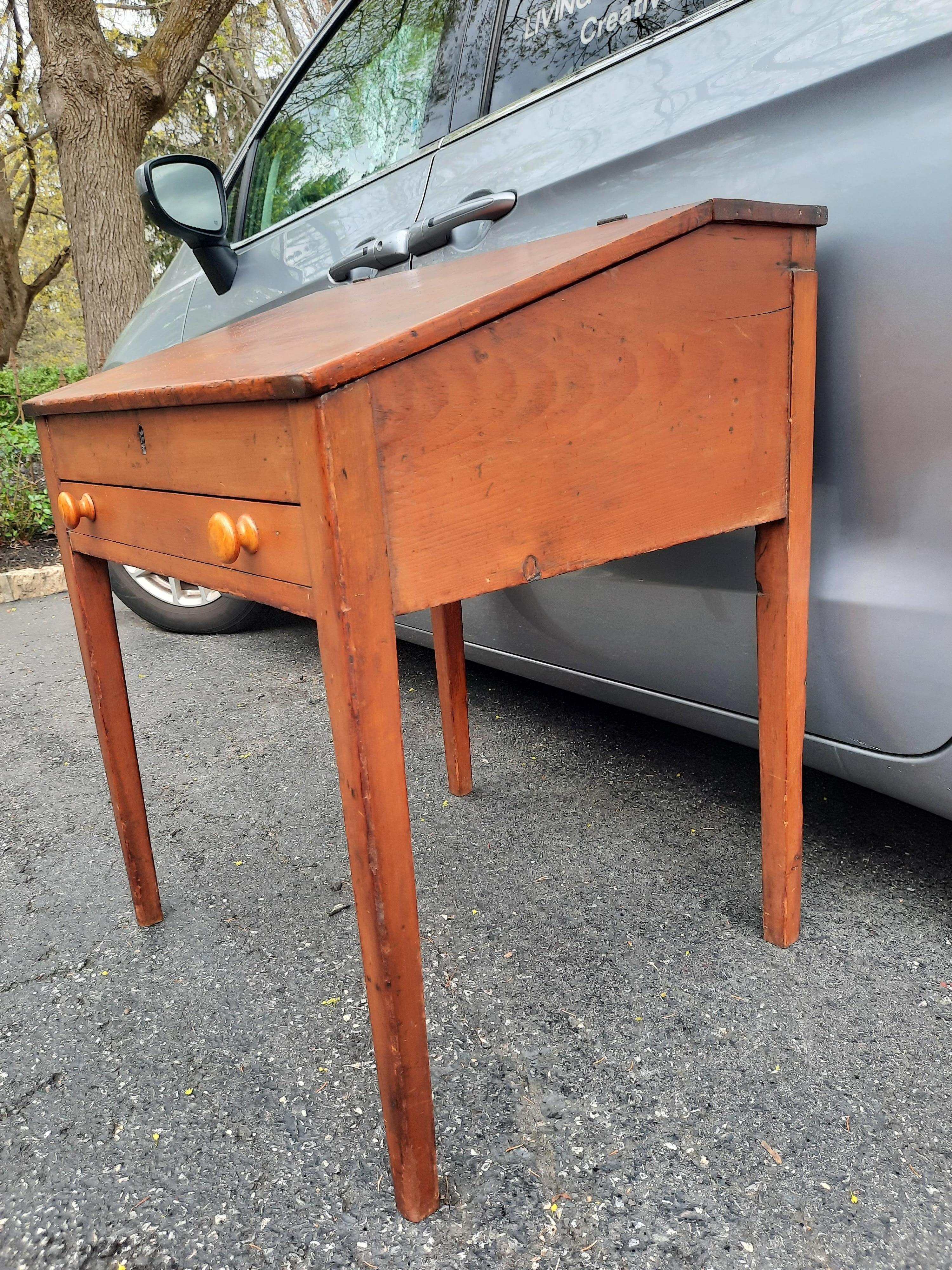 Antique American pine flip top desk. Beautiful natural patina with many signs of use. Very sturdy and solid. Wonderful storage under the angled writing surface. Beautiful details with the arched cubbies above two small drawers. One long draw in the