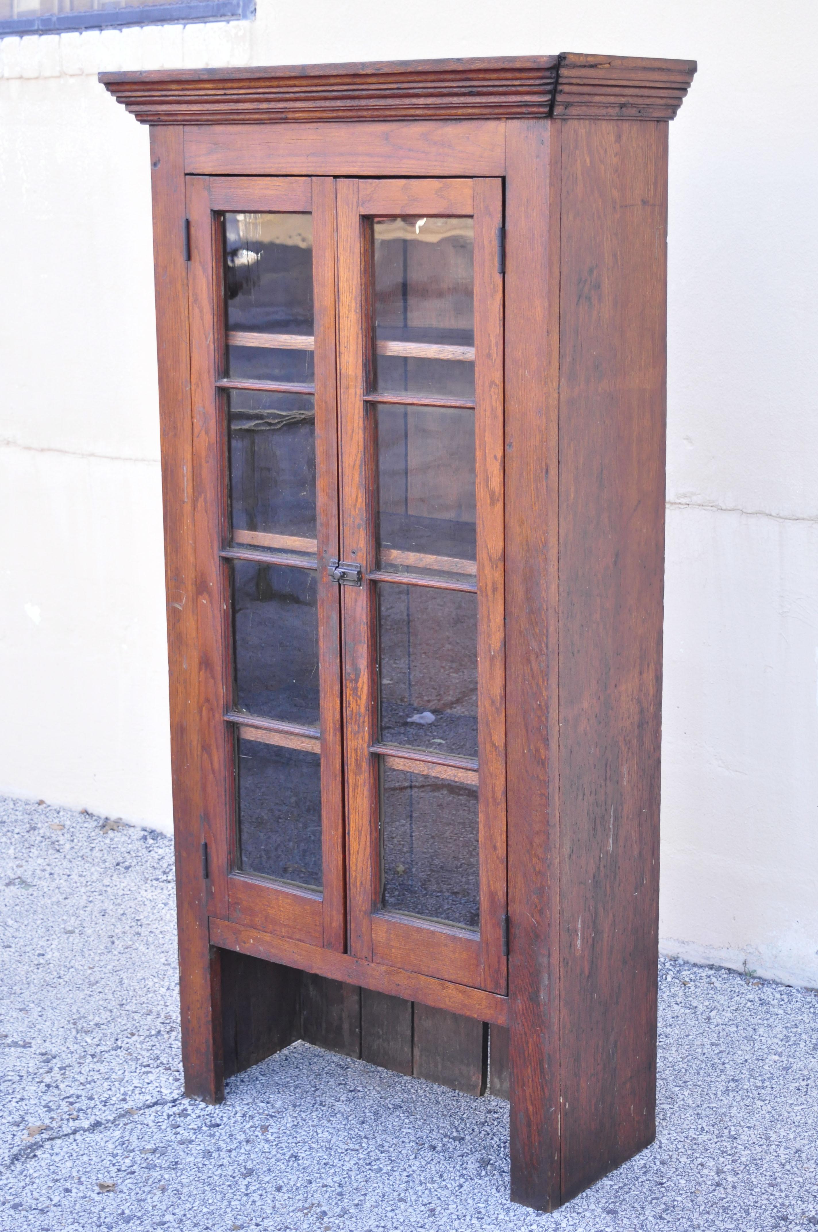 Antique American rustic oak wood cupboard cabinet hutch 2 glass doors. Item features solid wood construction, beautiful wood grain, distressed finish, 2 glass swing doors, very nice antique item, quality American craftsmanship, great style and form.