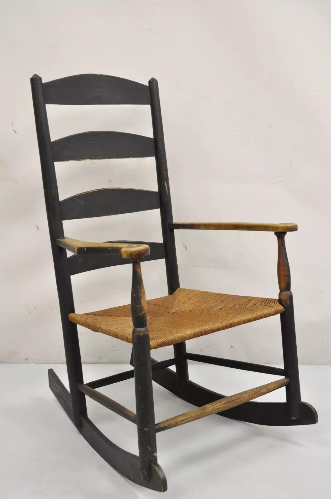 Ancienne chaise à bascule américaine rustique Shakers en bois ébonisé Siège en jonc fait à la main. Vers le début du 19e siècle. Dimensions : 43