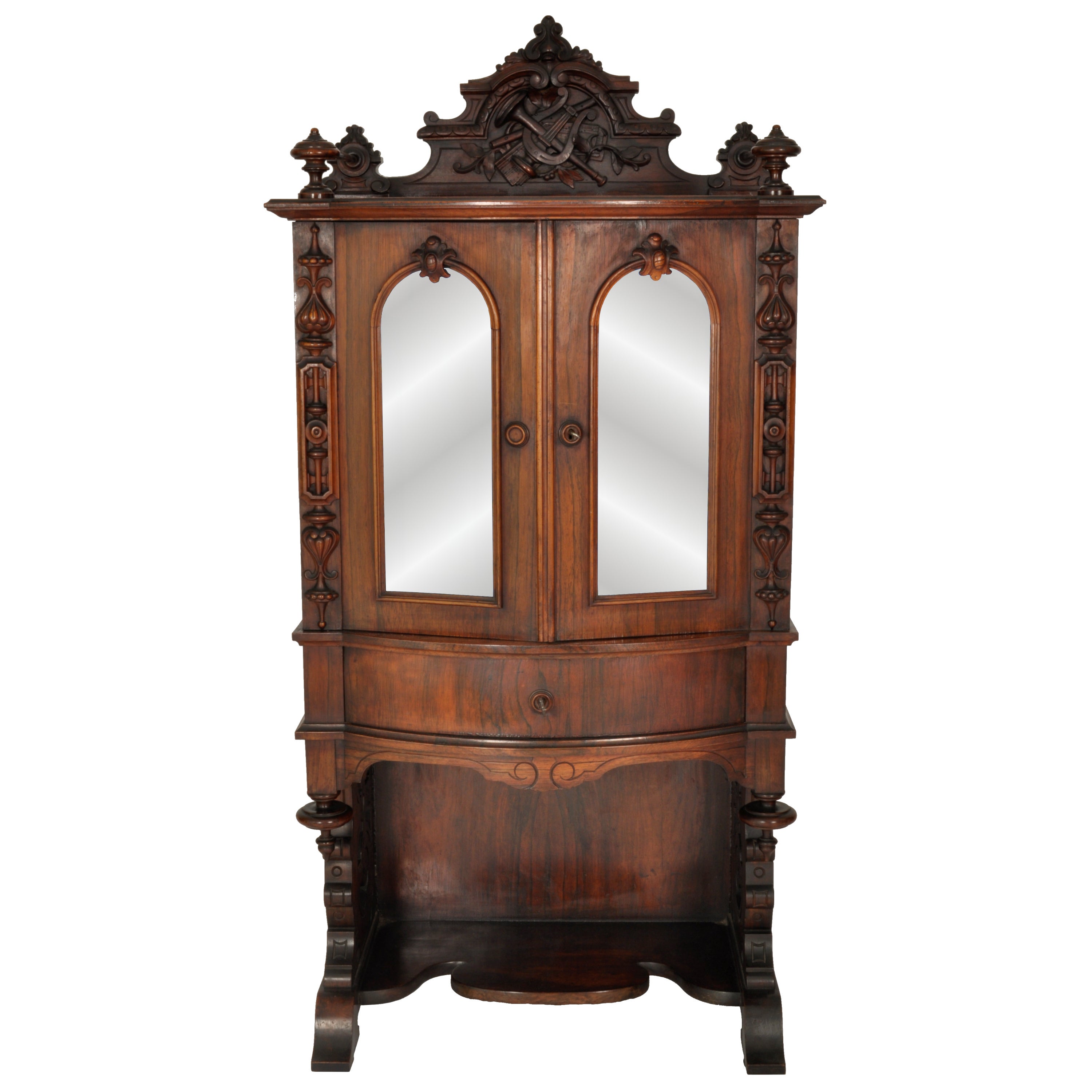 A fine antique American Renaissance Revival carved rosewood music cabinet, Circa 1870.
The top of the cabinet having a finely handcarved backcrest, carved with musical instruments and joined with a gallery stretcher to a pair of turned finials.