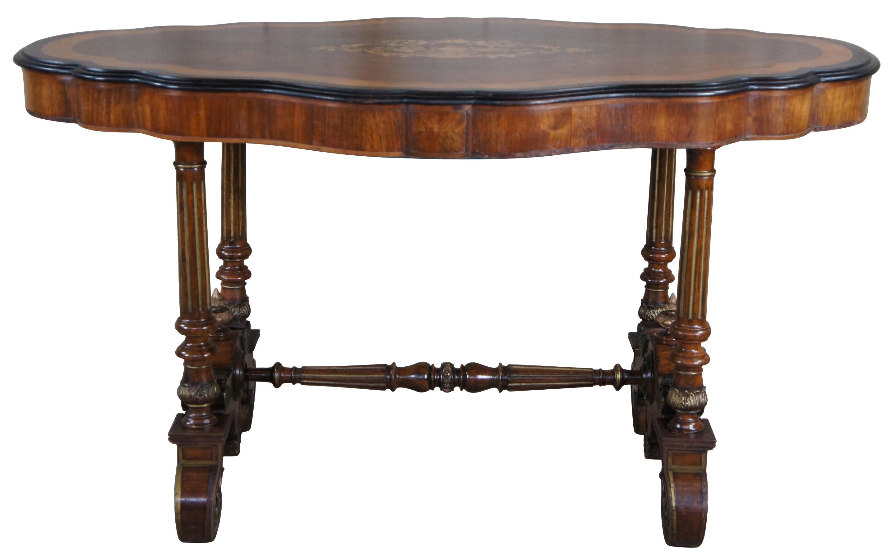 An exceptional American Renaissance Revival center table, circa late 19th century. Features a serpentine form with walnut burl top centered by floral marquetry, inlay and banding. The table is supported by turned and fluted columns leading to an