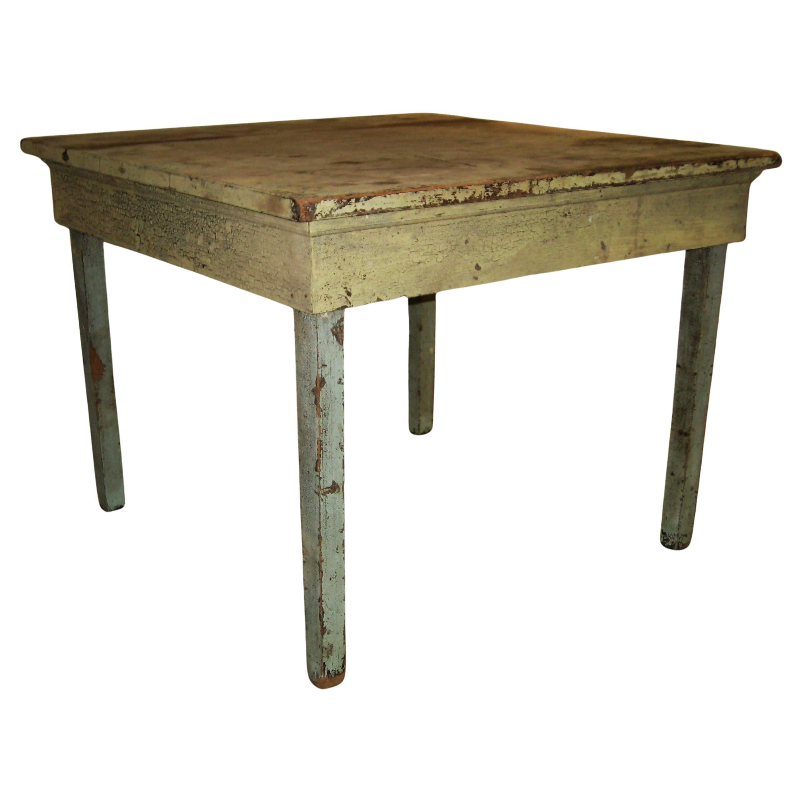 Antique American rustic farm work table in the original dry pale yellow and dry pale mint green paint showing good signs of genuine age w/ wear and alligatoring to surface. Wide four board top. Old handcrafted construction. Solid as a rock. Pictures