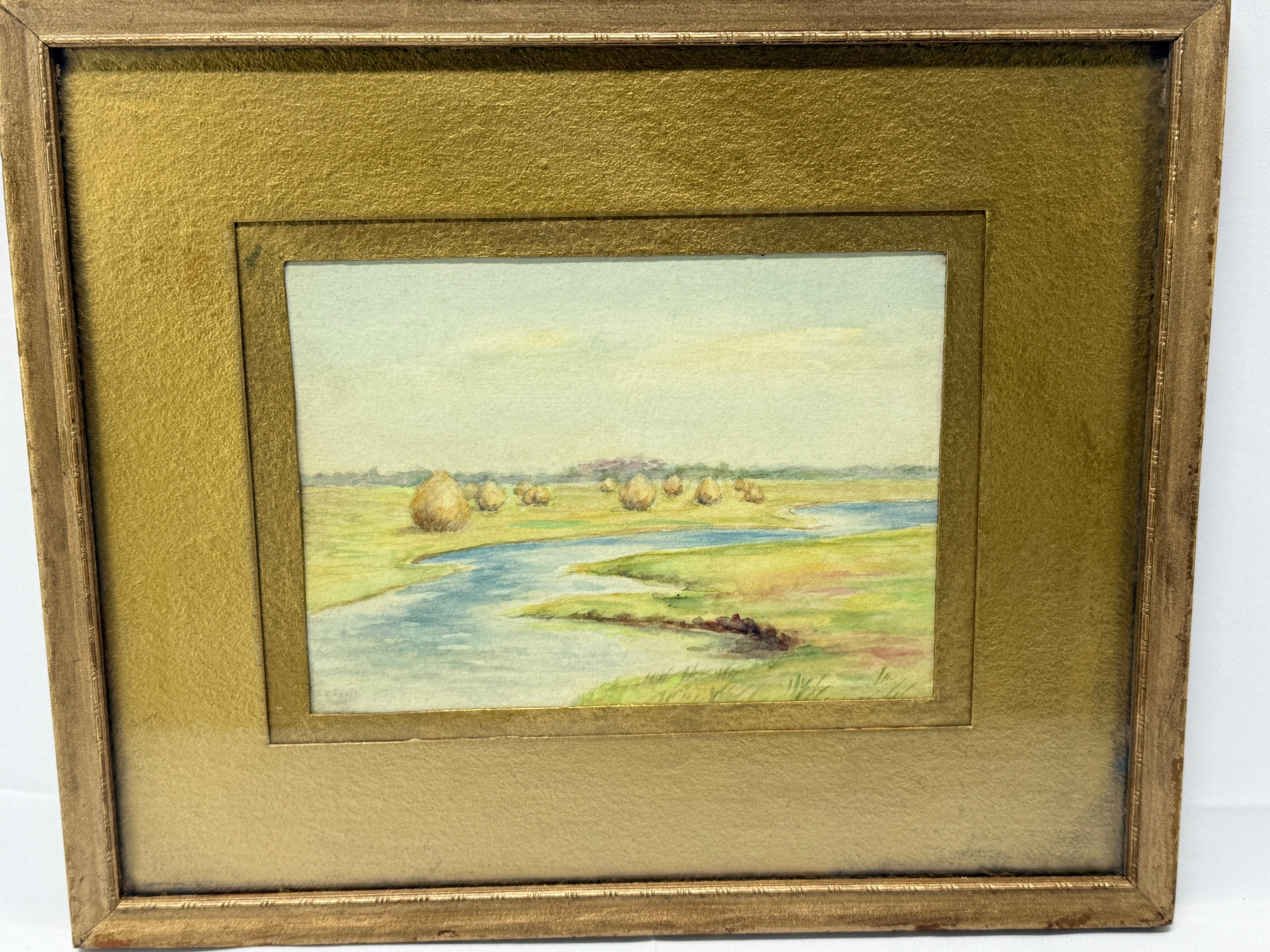 This finely executed watercolor painting depicts a tranquil pastoral landscape, featuring a gently winding river bordered by verdant meadows adorned with haystacks. The artist employs soft, natural tones and meticulous brushwork to capture the