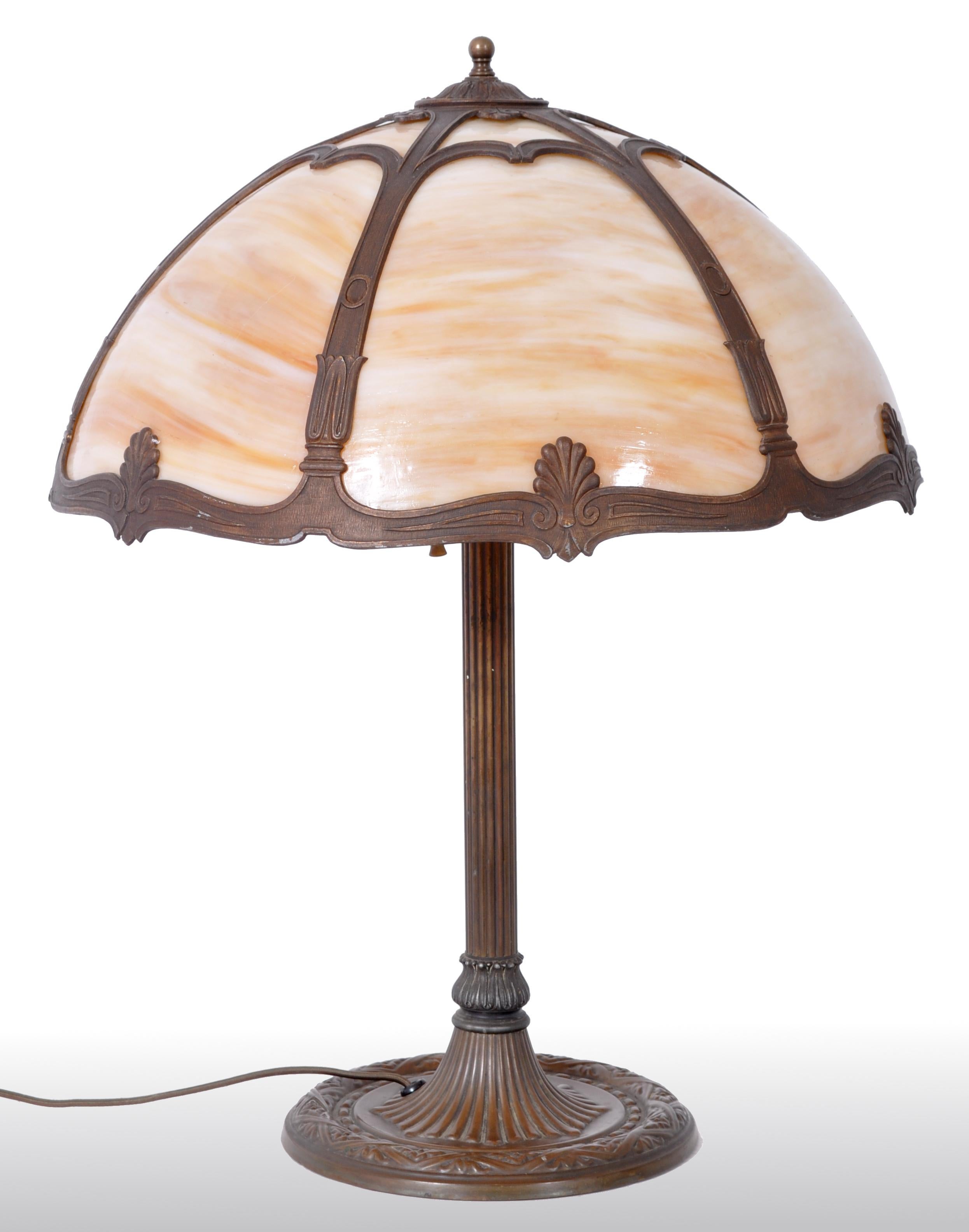 Antique American Art Nouveau slag glass and bronze table lamp by Bradley & Hubbard, circa 1915. The lamp having a six-panel striated caramel slag glass shade above a bronze column base. The lamp having twin fixtures with the original pull-chains,