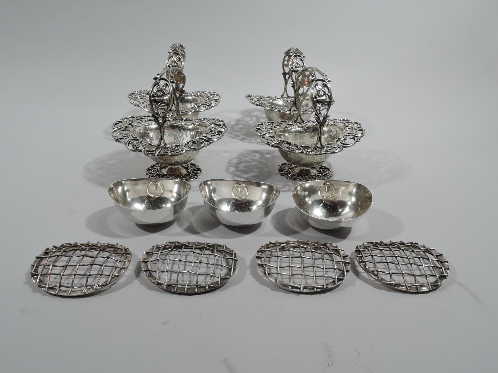 American sterling silver 5-basket garniture, ca 1890. Retailed by Bailey, Banks & Biddle in Philadelphia. There are 4 small baskets and 1 large basket. Each: Oval bowl with fixed c-scroll handle and raised oval foot. Open flowering scrollwork on rim