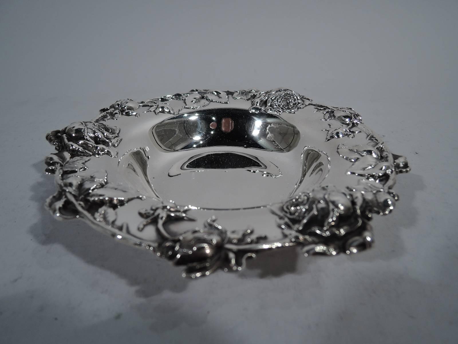 Pretty turn-of-the-century sterling silver bowl. Made by Redlich in New York. Plain well with tapering sides and wide rim. Applied flowering rose branch with ripe blooms and young buds. Hallmark includes no. 4682. Weight: 6 troy ounces.
