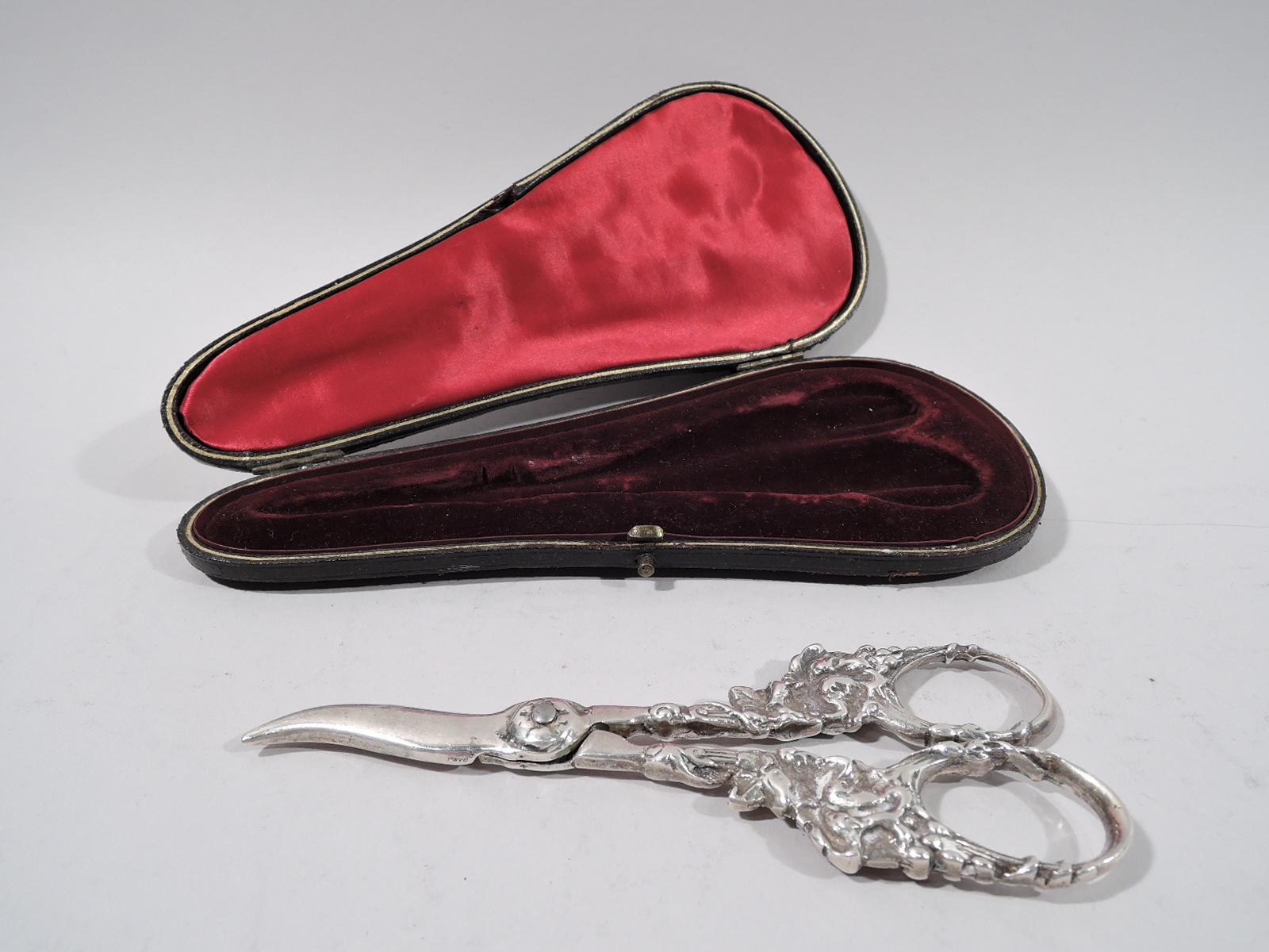 American sterling silver grape shears, circa 1920. Handles in form of fruiting grapevine, which wraps around the finger rings. In leather-bound case with silk lining and fitted velvet. Scissors marked “Sterling”. 

Dimensions: Scissors: H 6 in.