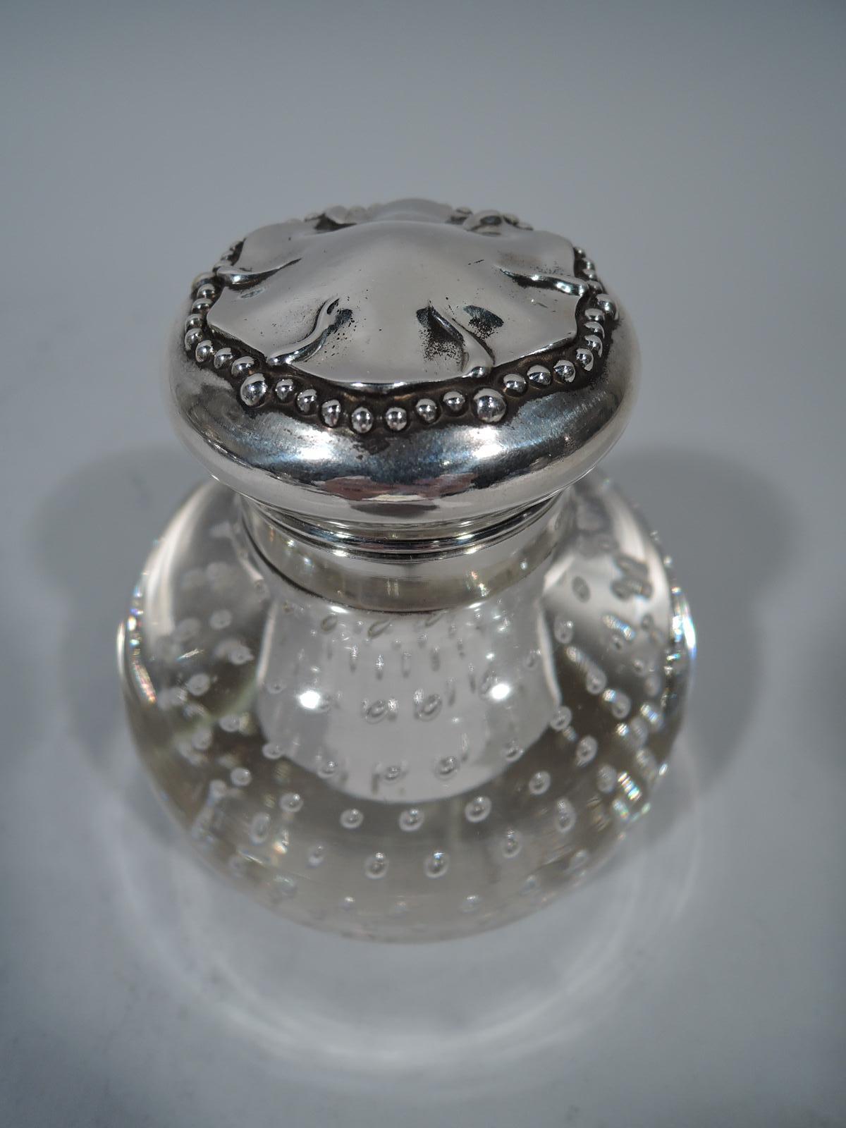 Turn-of-the-century sterling silver and pairpoint glass inkwell. Plain, round, and upward tapering well with pointed bottom set in globe with controlled bubbles. Short neck in sterling silver collar with hinged and bellied cover, also sterling