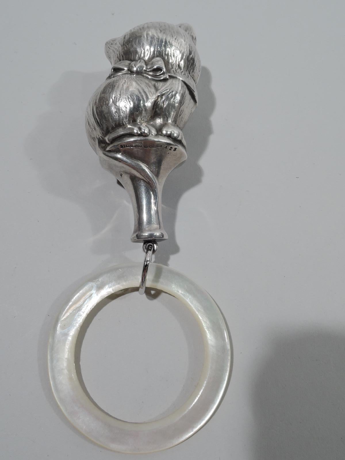 Edwardian sterling silver baby rattle. Made by R. Blackinton & Co. in North Attleboro, Mass., ca 1910. Feline figure with erect ears, self-satisfied expression, fluffball haunches, and tail hanging over and wrapping around the pedestal to which is
