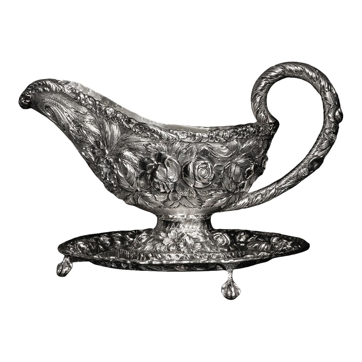 Una buena salsera antigua americana de plata esterlina repoussé sobre soporte, S. Kirk & Sons Co., Baltimore, hacia 1920.
Fina salsera de plata de ley con soporte, de forma ovoide con boca en forma de casco y elevada sobre un pie ovalado, finamente