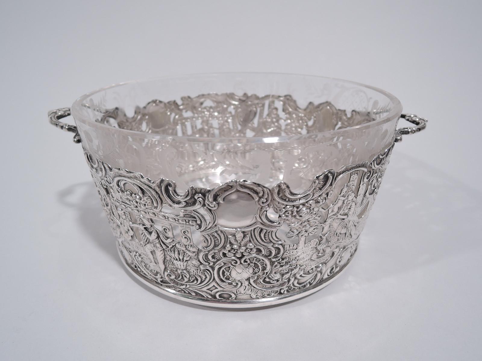 Turn-of-the-century American sterling silver ice bucket. Round with fixed scroll-handles mounted to rim. Pierced and repousse frieze depicting piping and strumming troubadours and recumbent females. Sweet and sentimental in the German style.