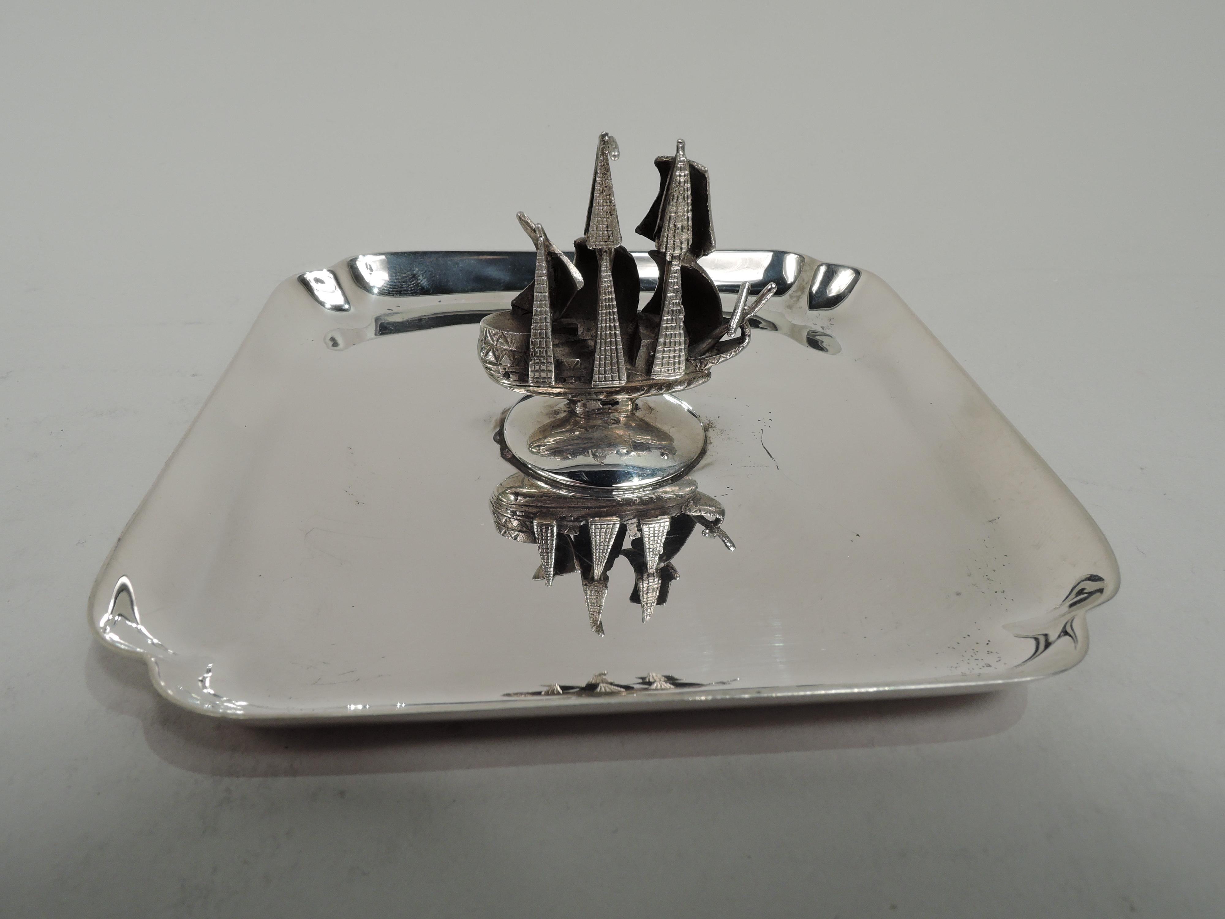 American sterling silver vide-poche, ca 1920. Square with lobed corners. Mounted to center is 3-mast galleon with billowing sales and delineated wood hull. Marked “Sterling / 5”. Weight: 3 troy ounces.